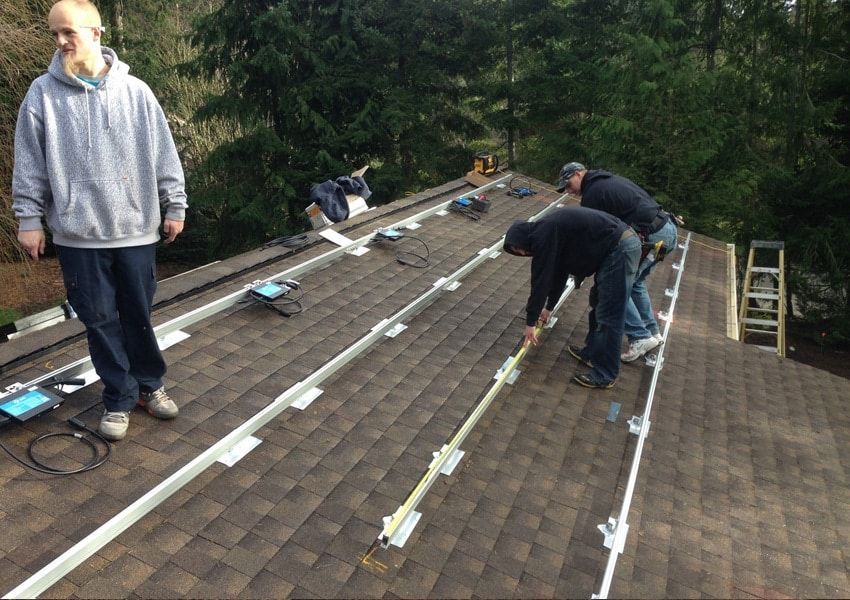 a group of men are working on the roof of a house