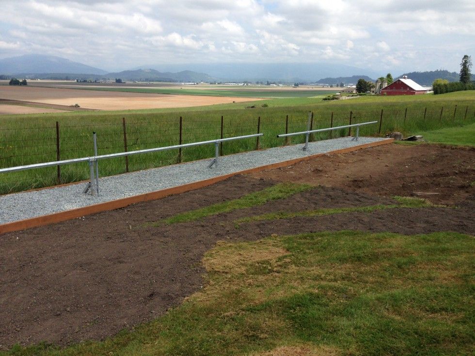 a gravel path with a fence in the background