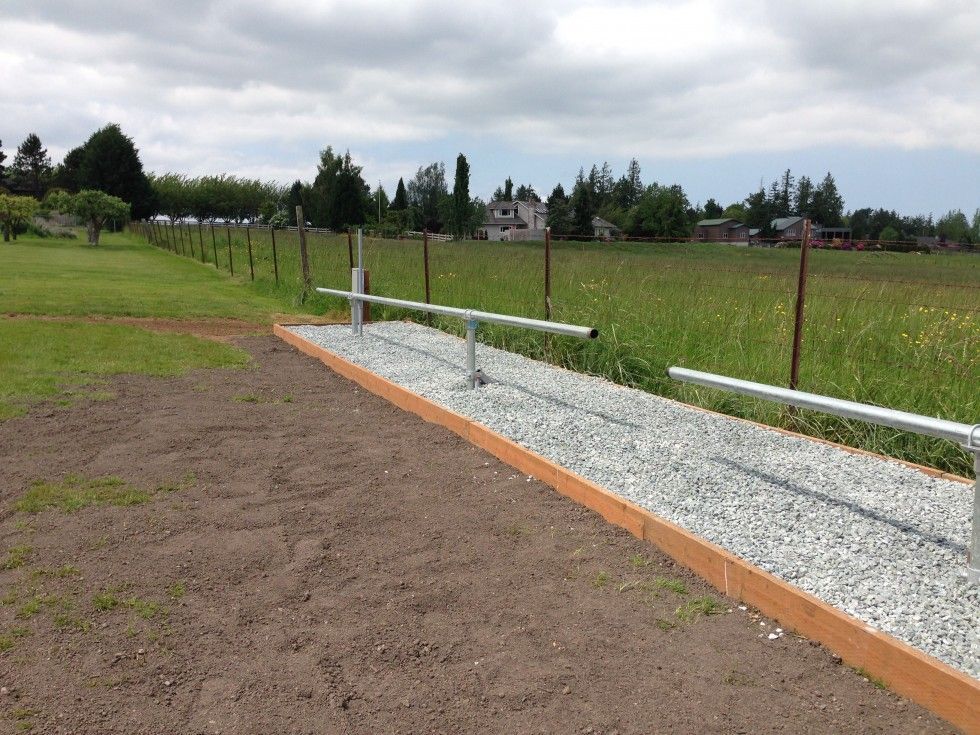 a gravel path with a fence in the background