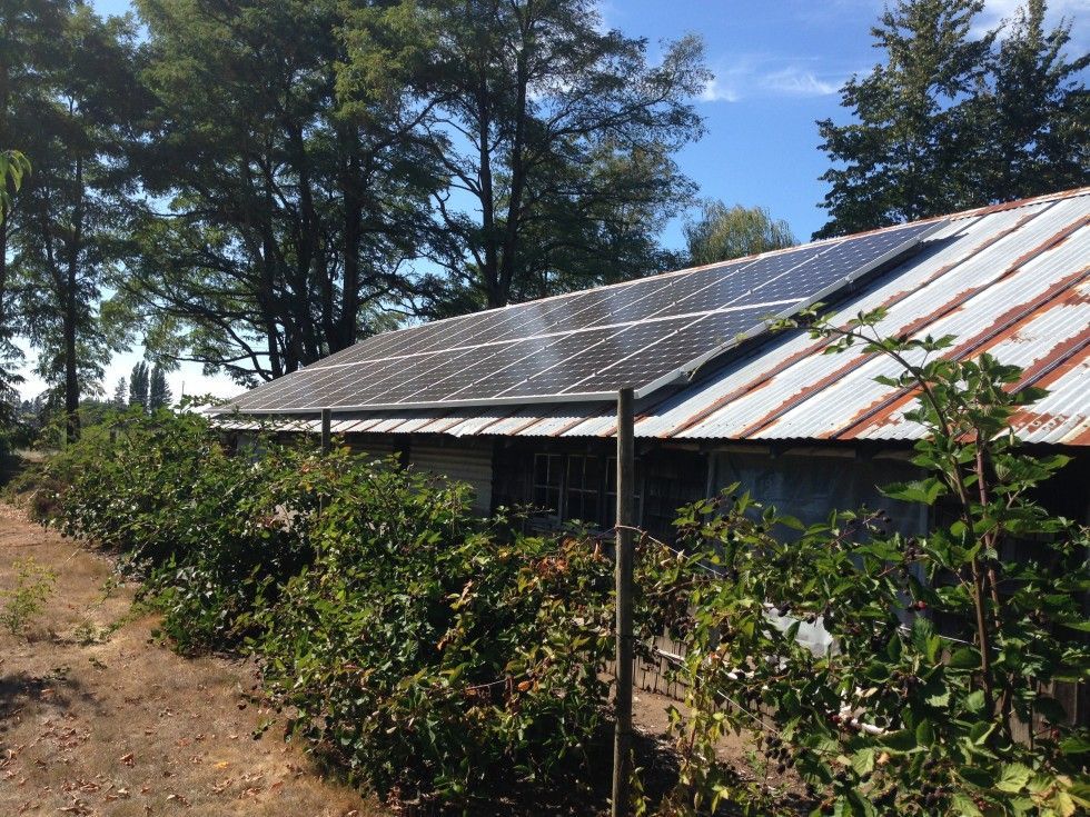 a house with solar panels on the roof is surrounded by trees