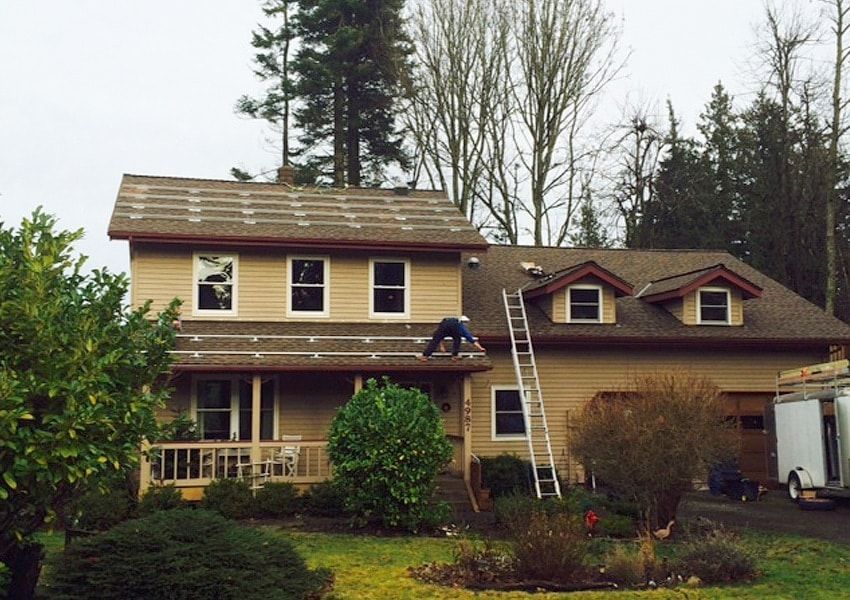 a man is working on the roof of a house