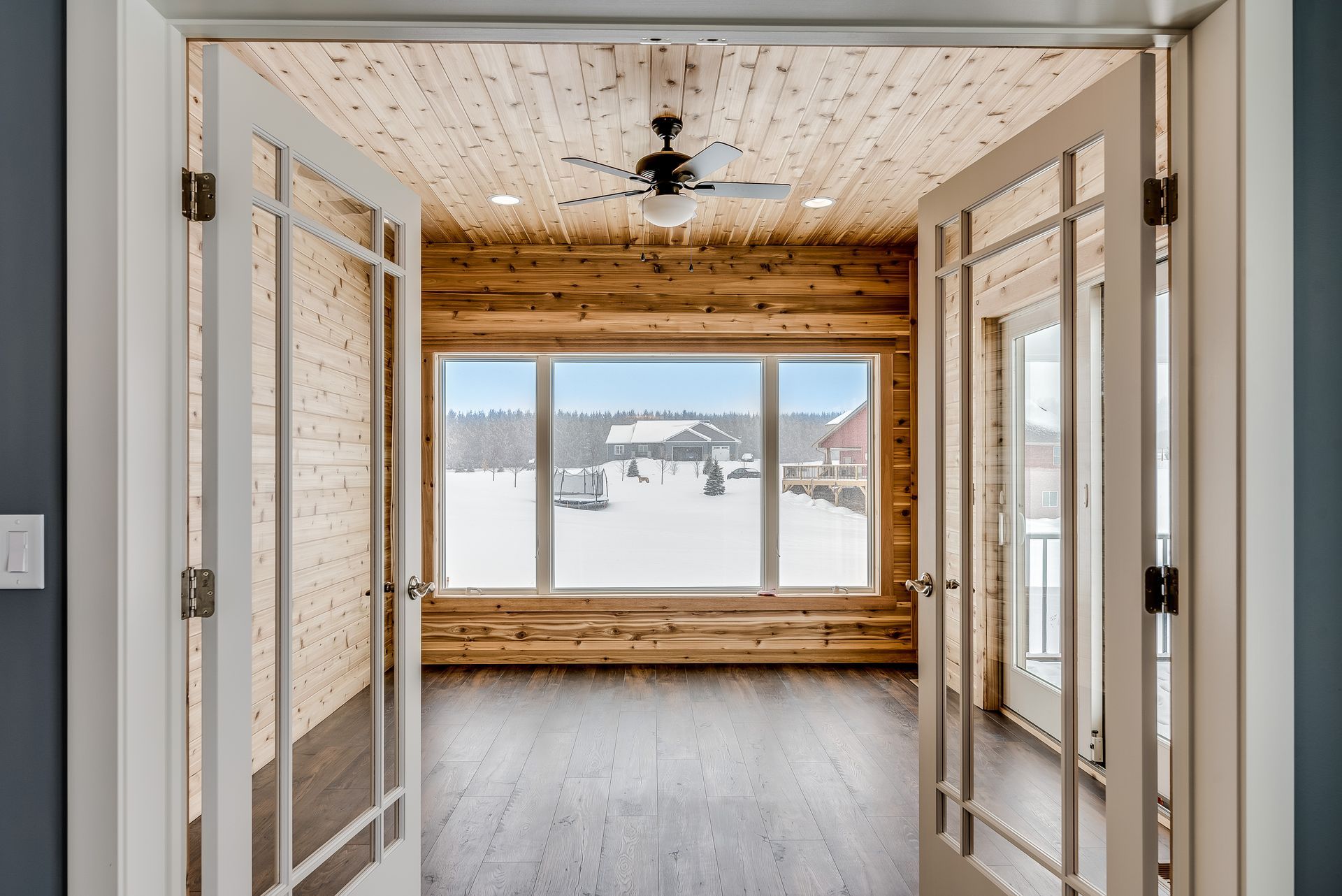 A room with a lot of windows and a ceiling fan.