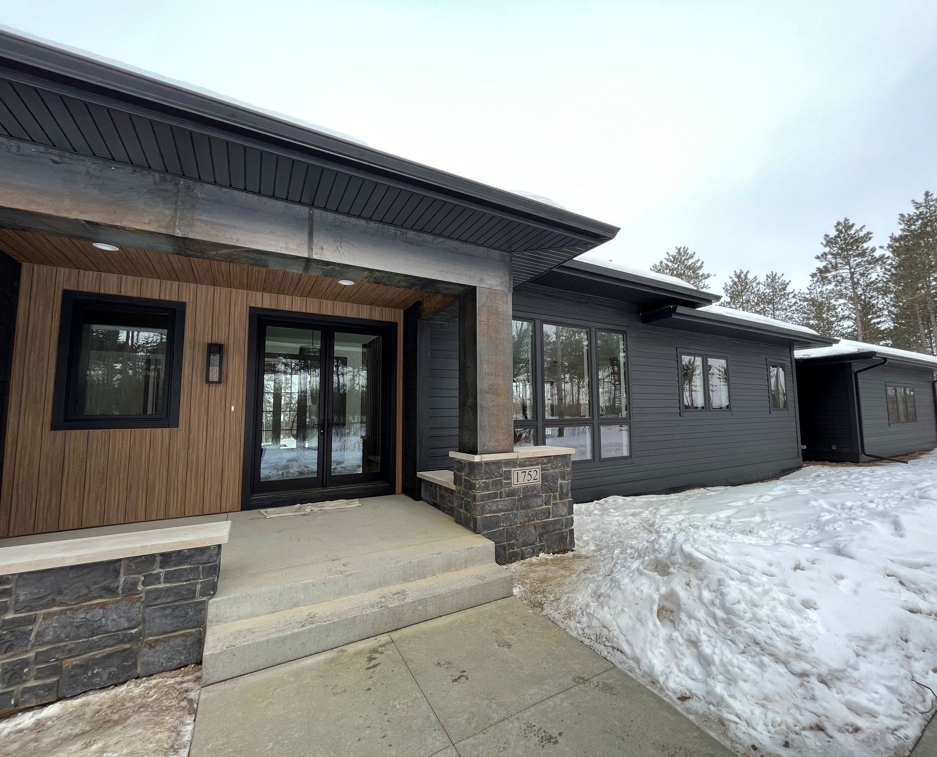 A large house with a lot of windows is covered in snow.