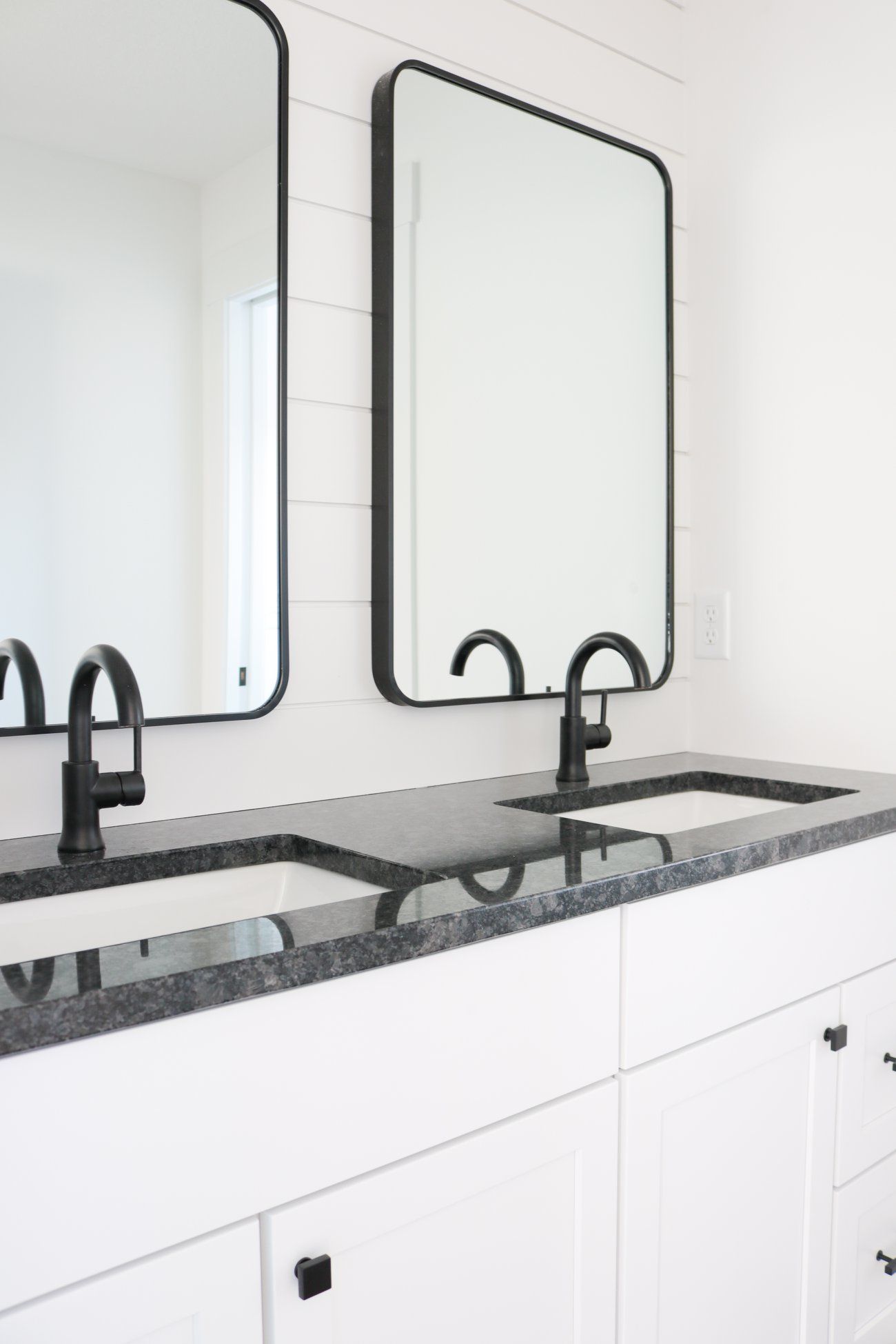 A bathroom with two sinks and two mirrors.