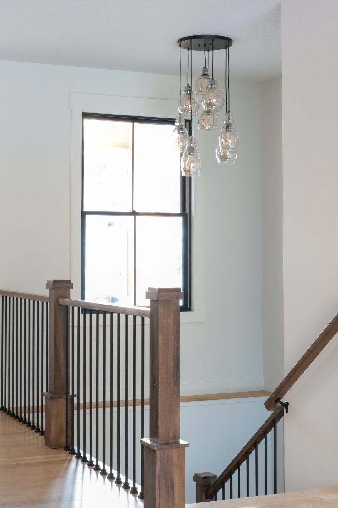 A staircase with a wooden railing and a window.