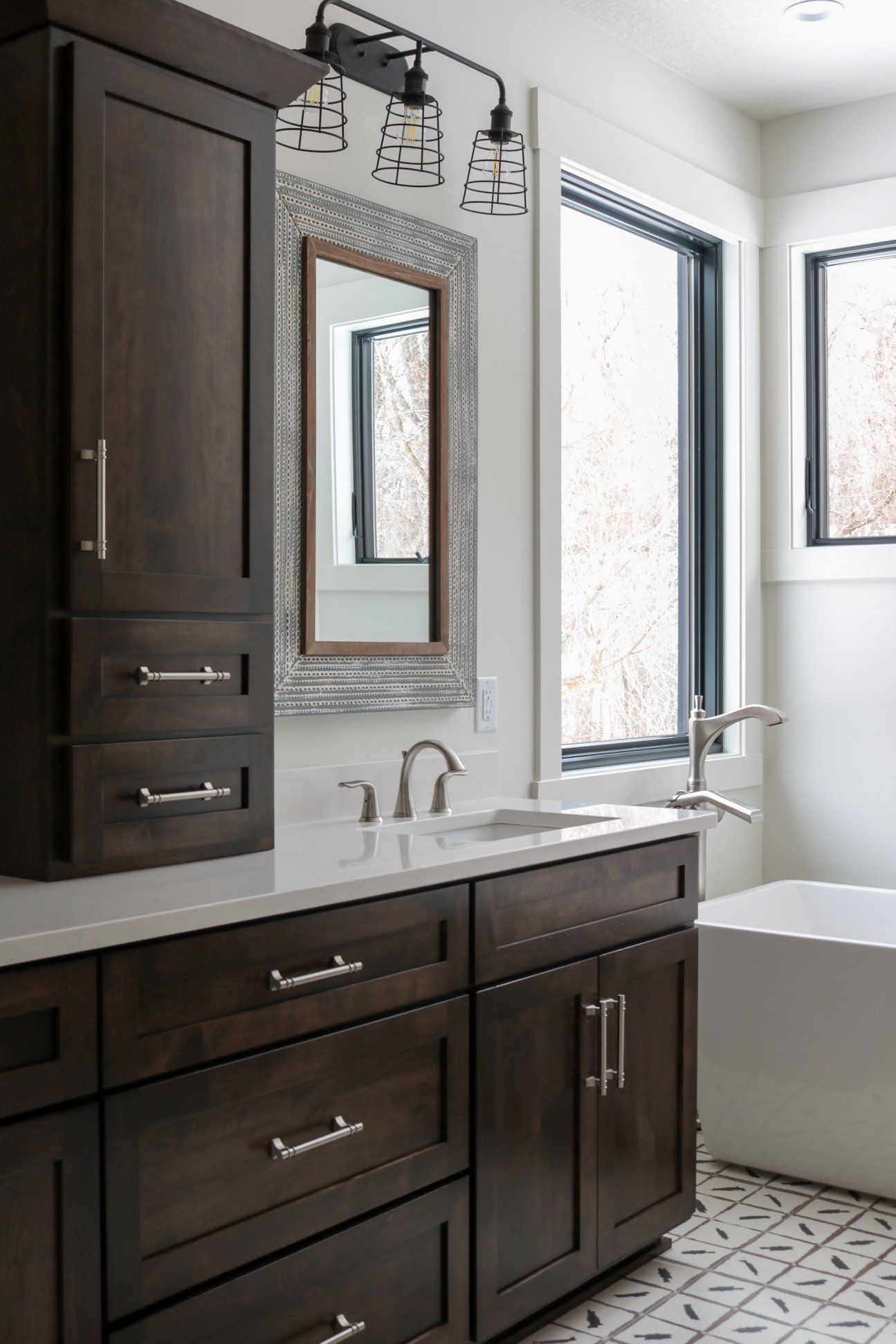 A bathroom with a sink, mirror and tub.
