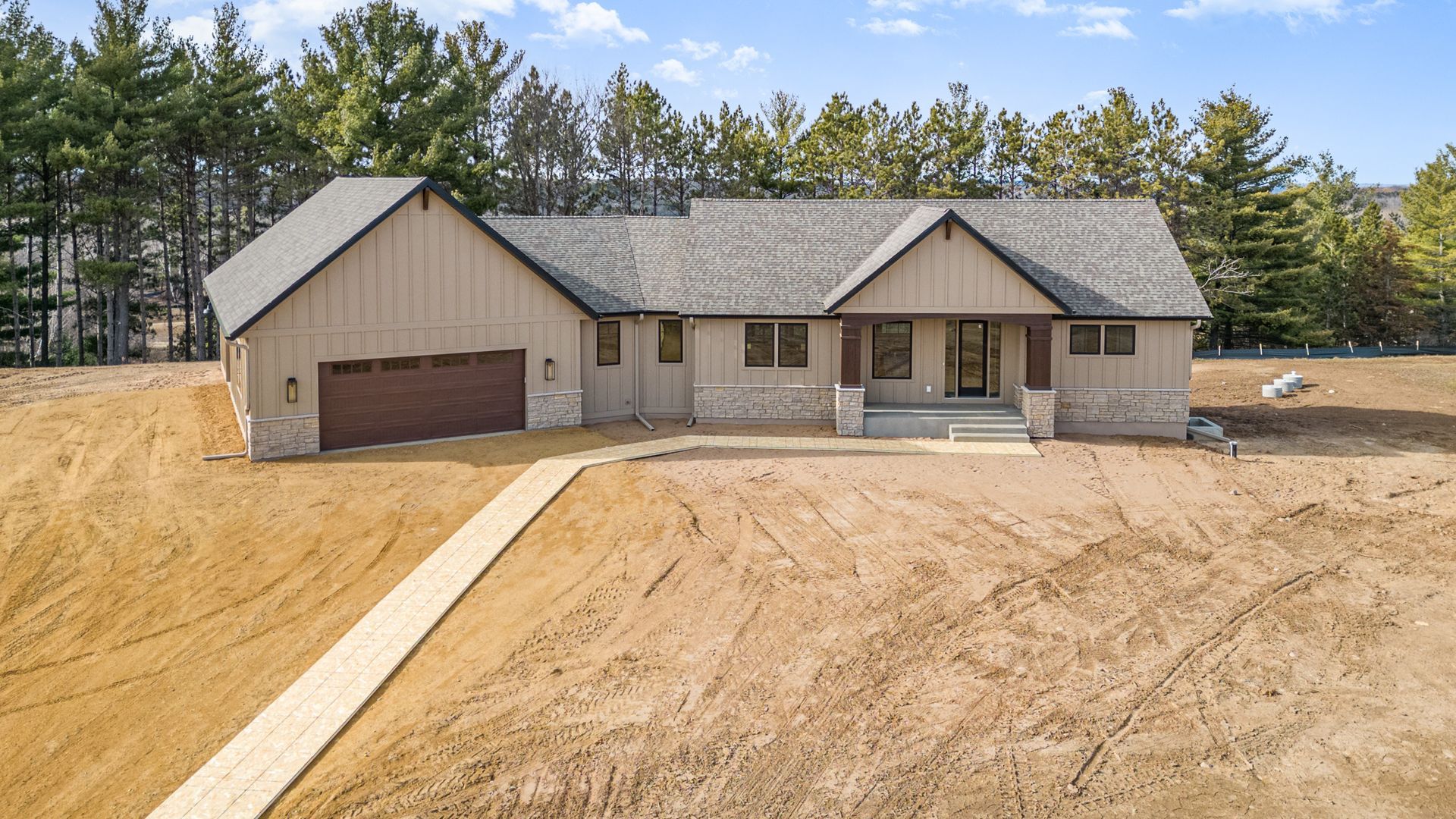 An aerial view of a house in the middle of a dirt field.