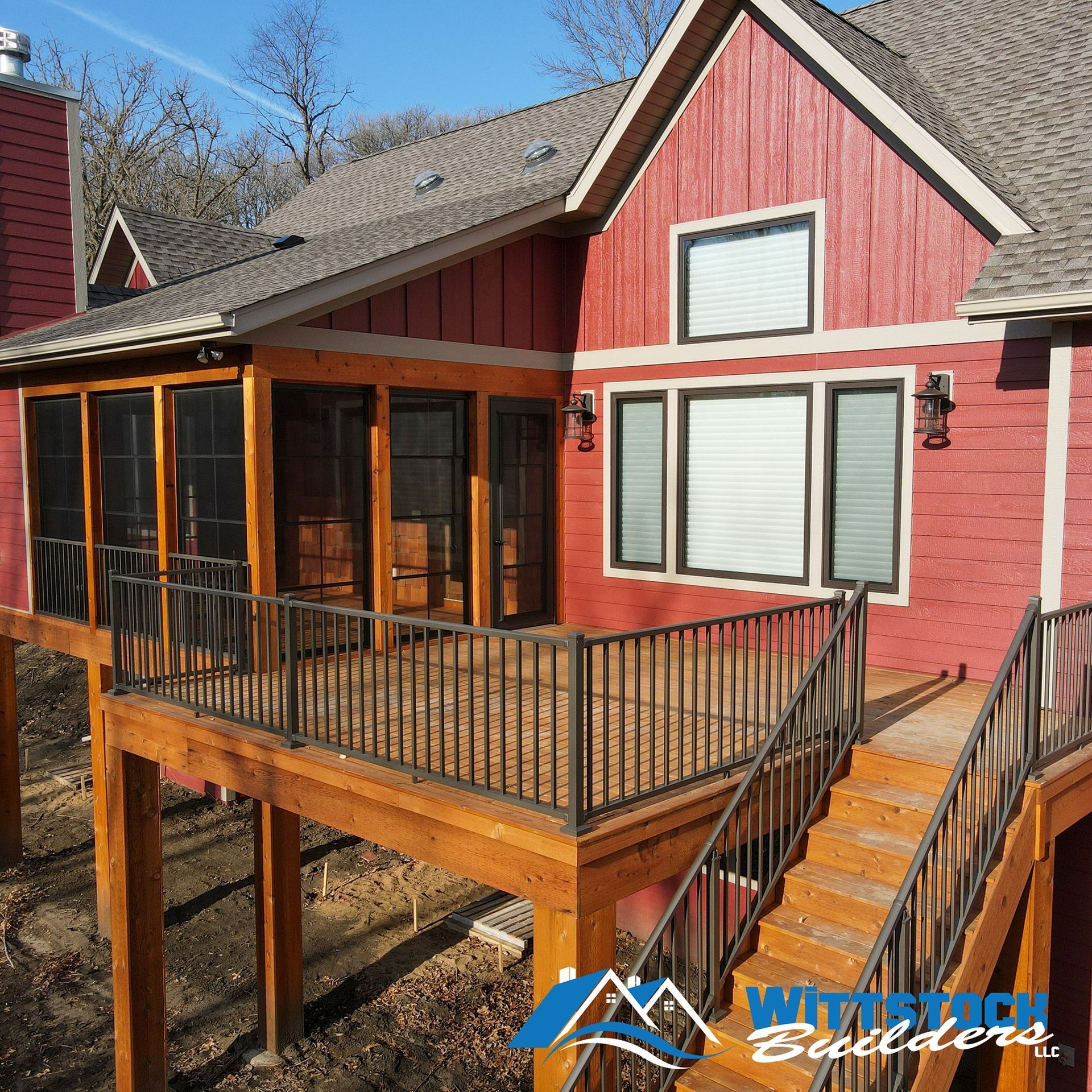 A red house with a screened in porch and stairs