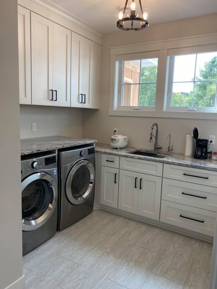 A laundry room with a washer and dryer and a sink.