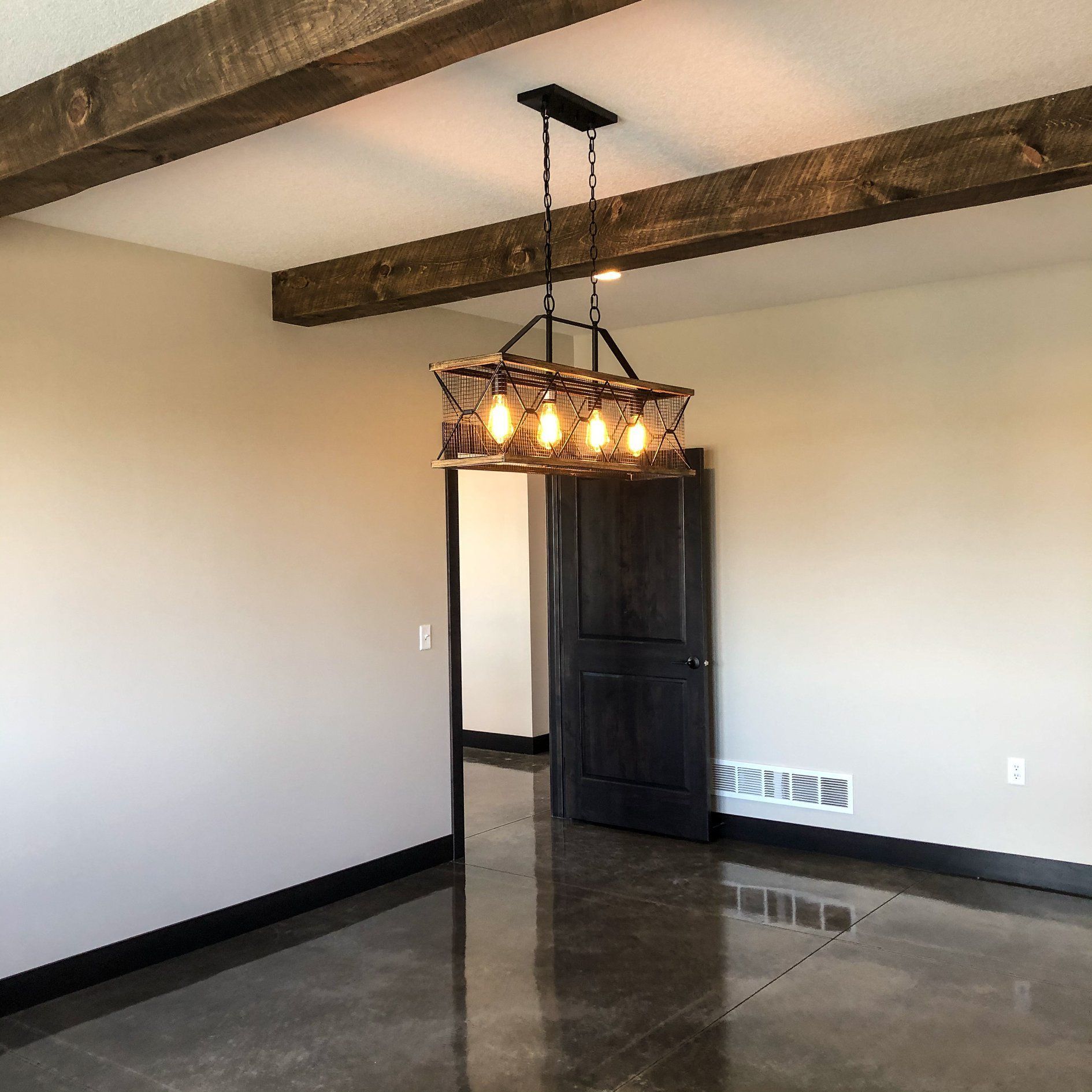 An empty room with a chandelier hanging from the ceiling