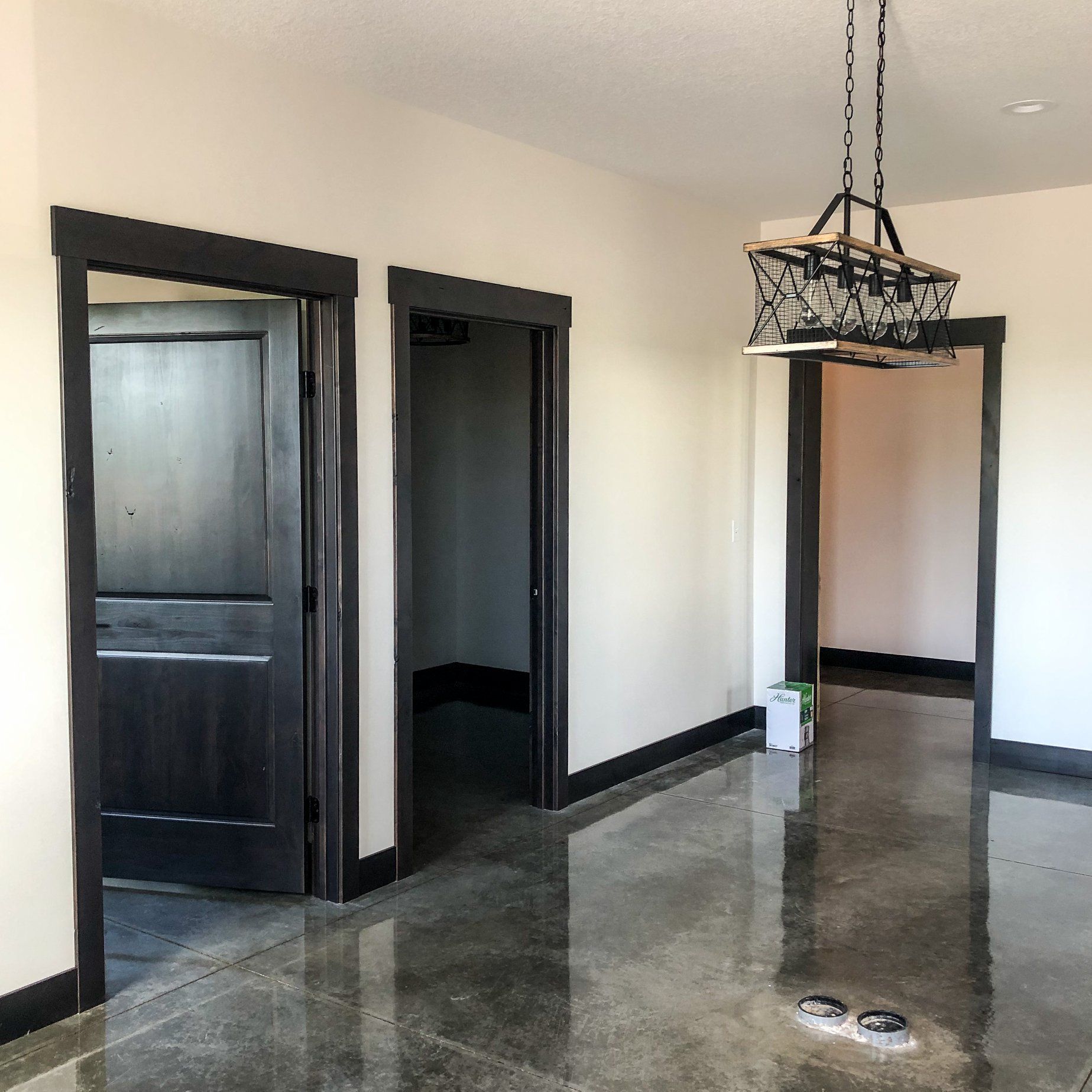 An empty room with a chandelier hanging from the ceiling