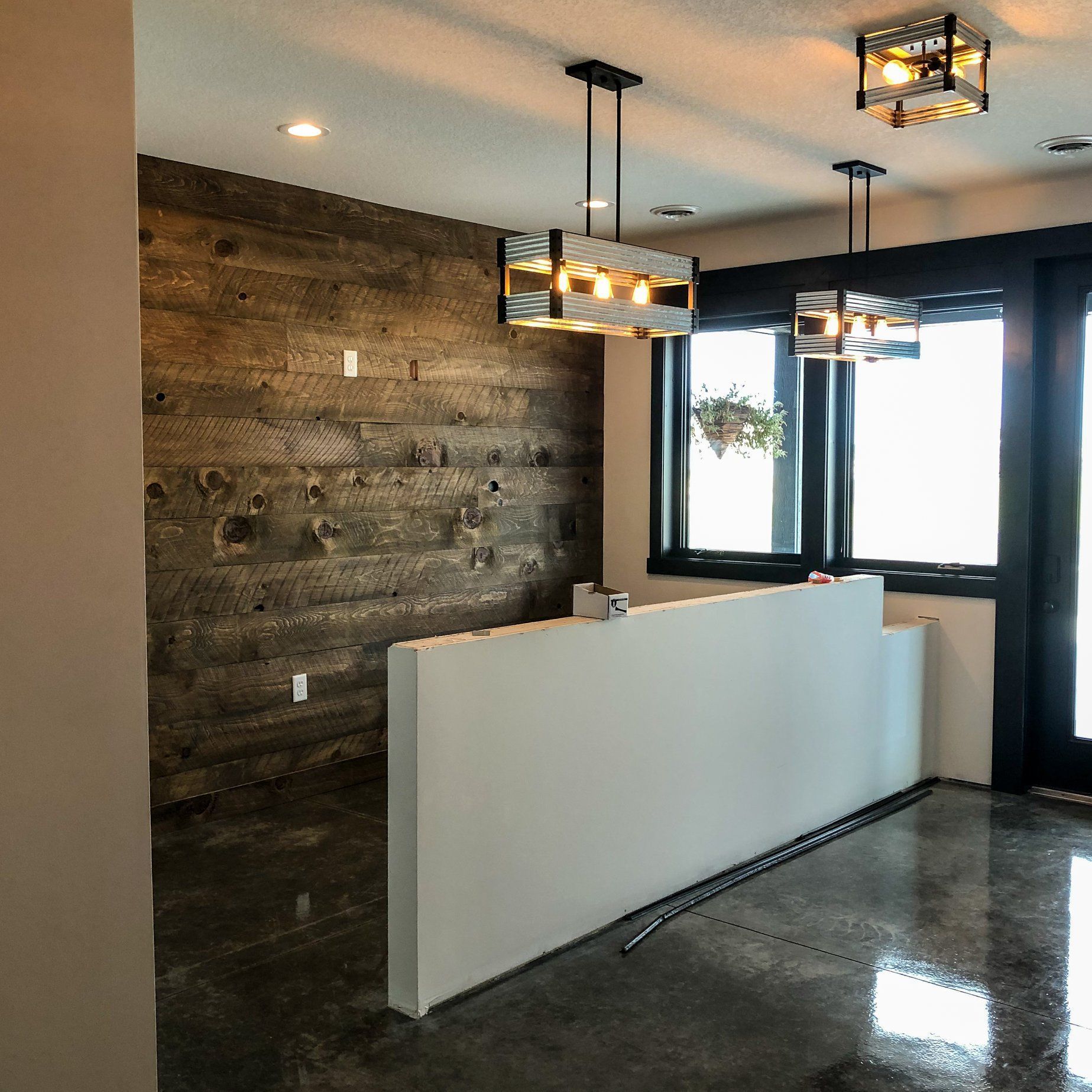 A room with a wooden wall and a white counter