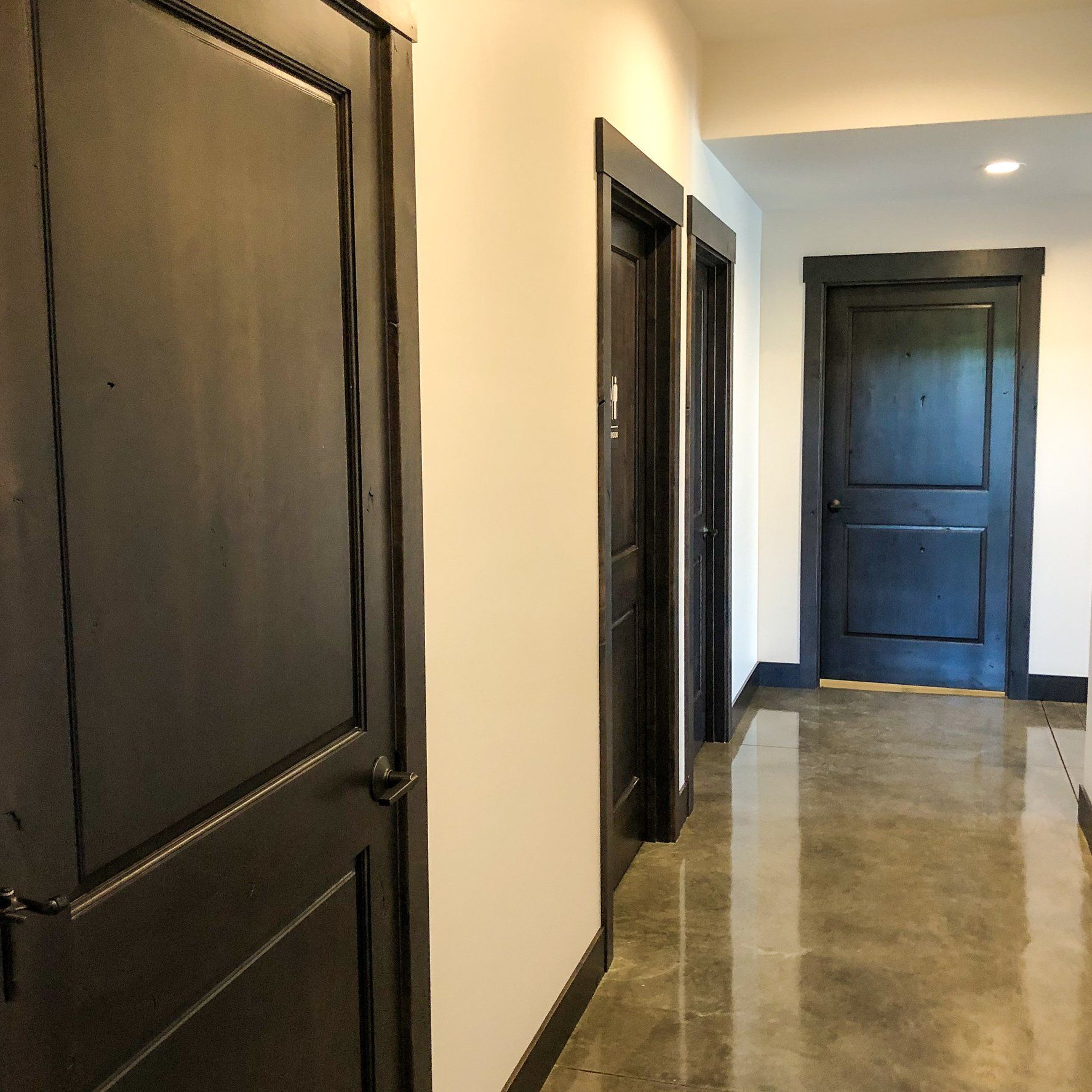 A hallway with black doors and white walls