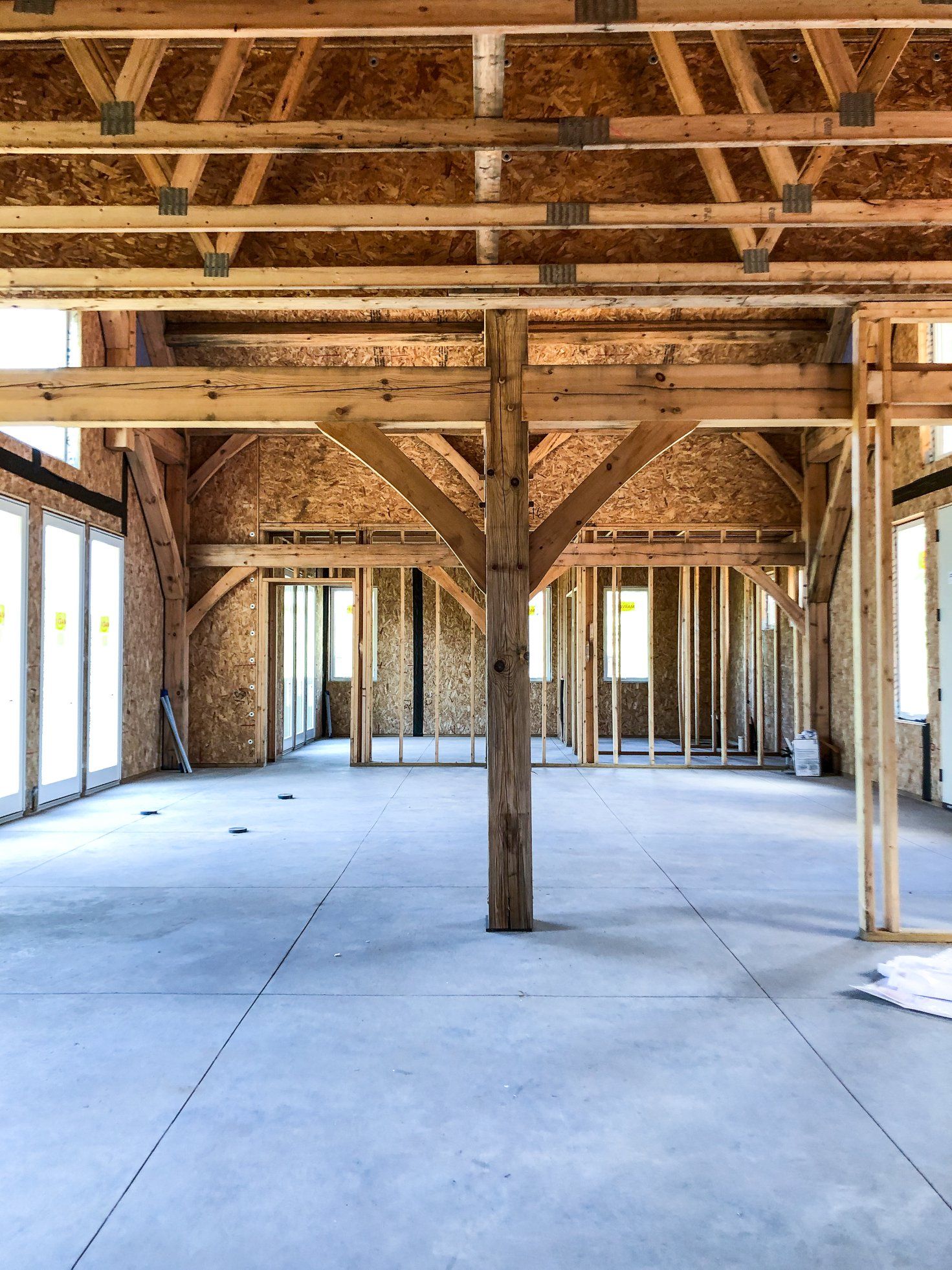A large empty room with wooden beams and a concrete floor.
