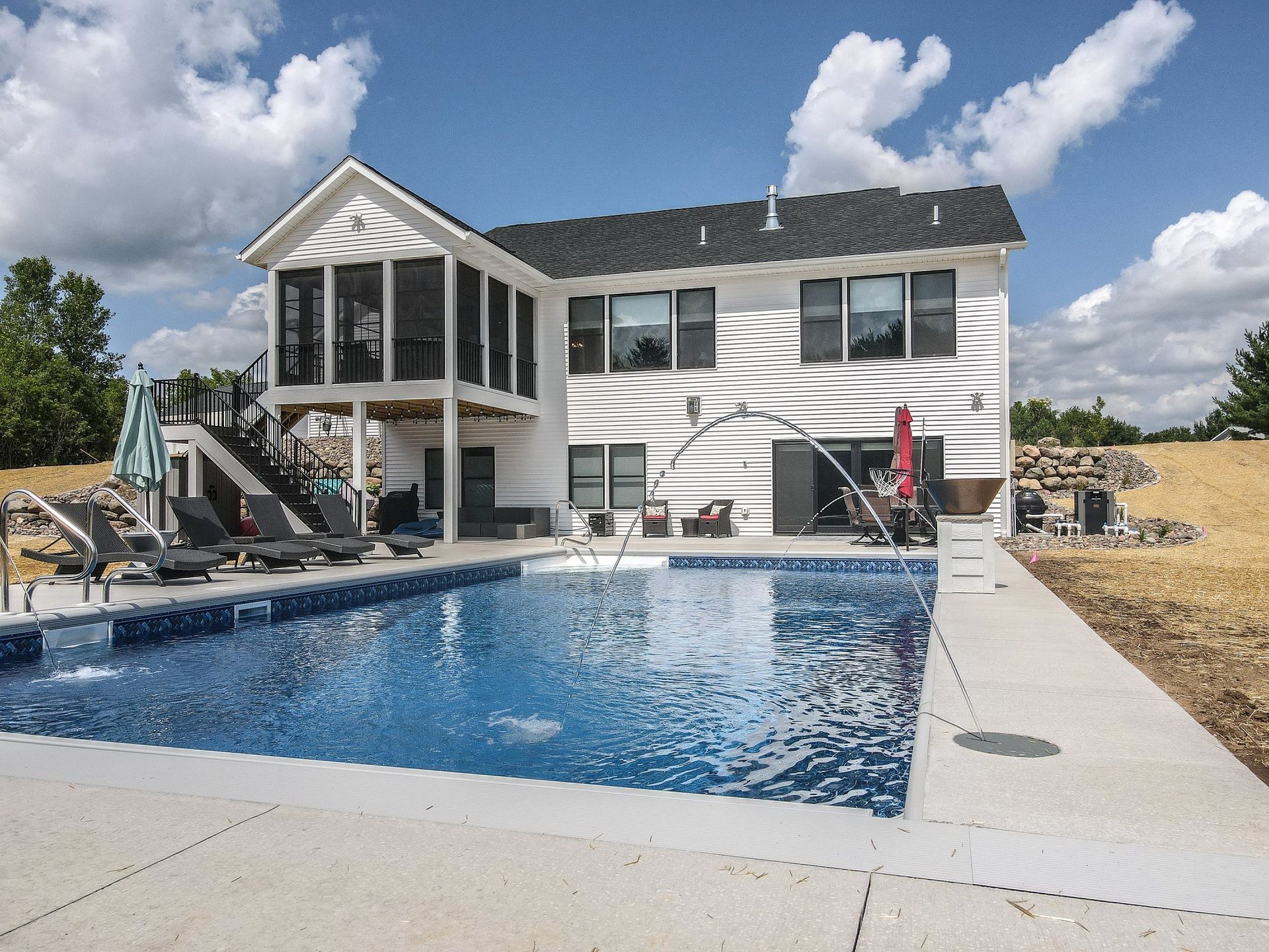 A large white house with a large swimming pool in front of it