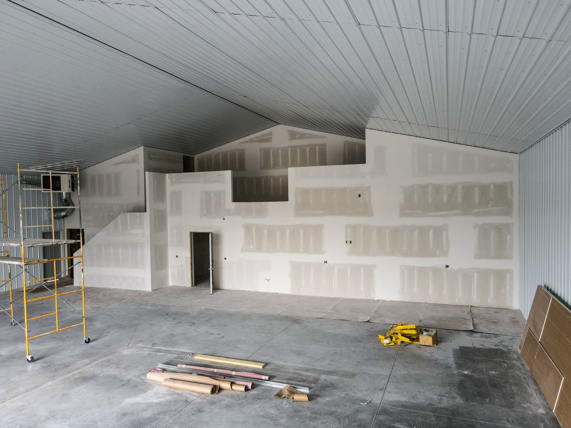A large room with a lot of drywall and scaffolding