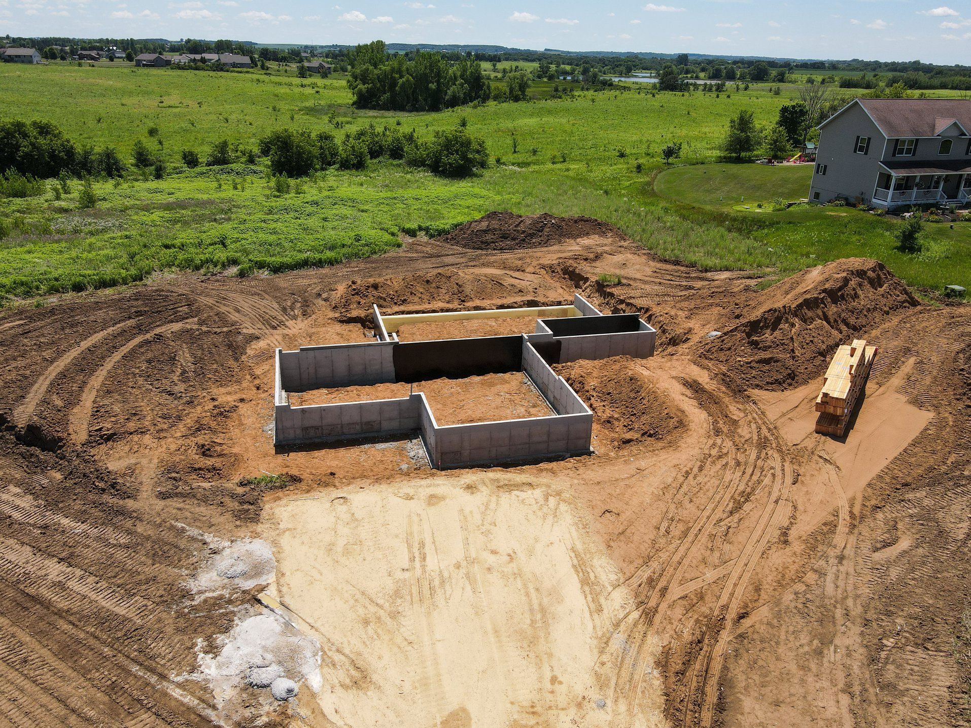 An aerial view of a house under construction in a dirt field.