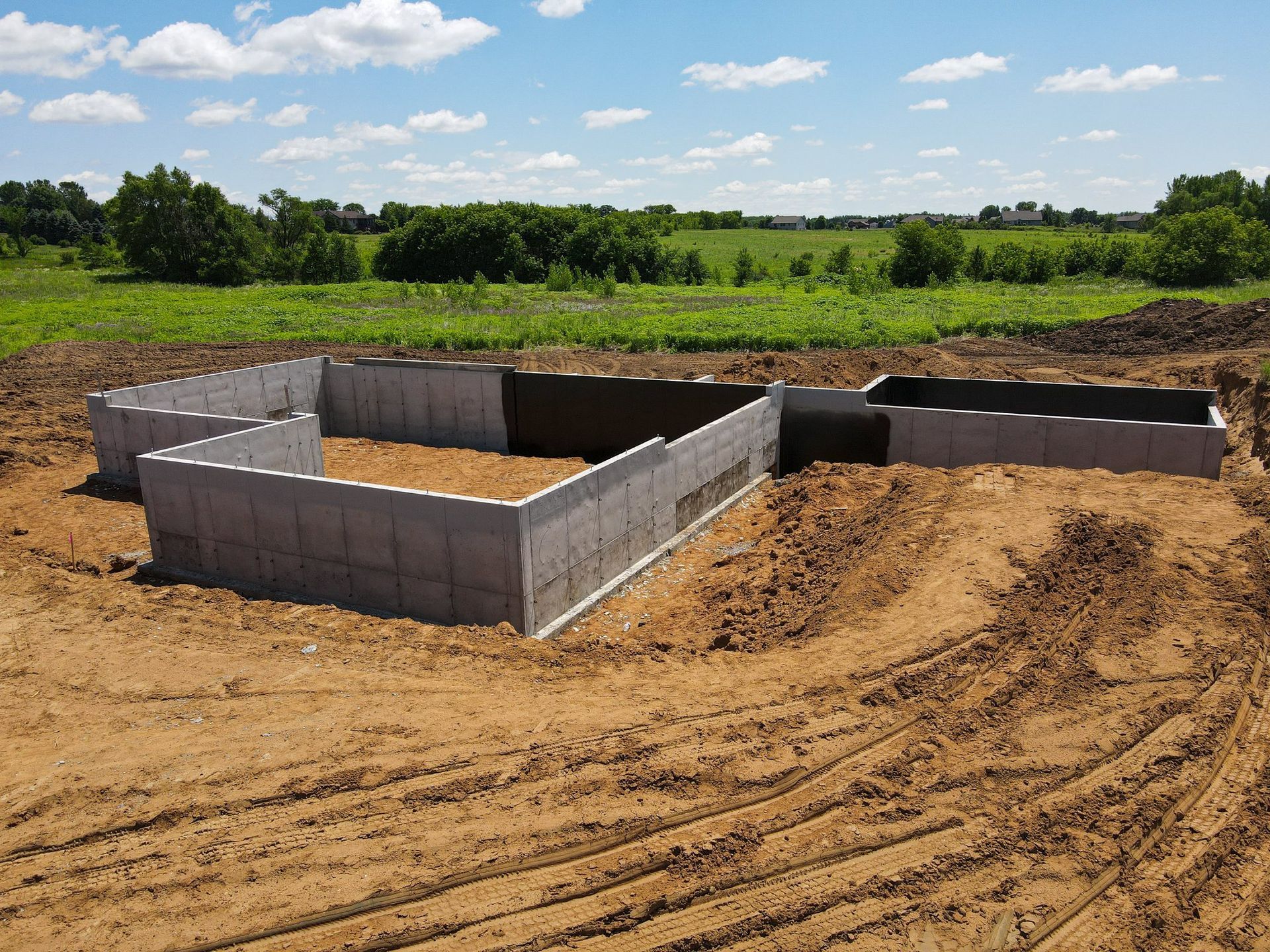 A concrete foundation is being built in a dirt field.
