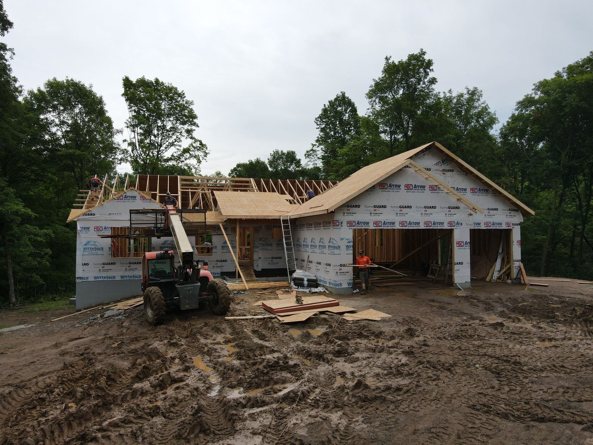 A tractor is parked in front of a house under construction