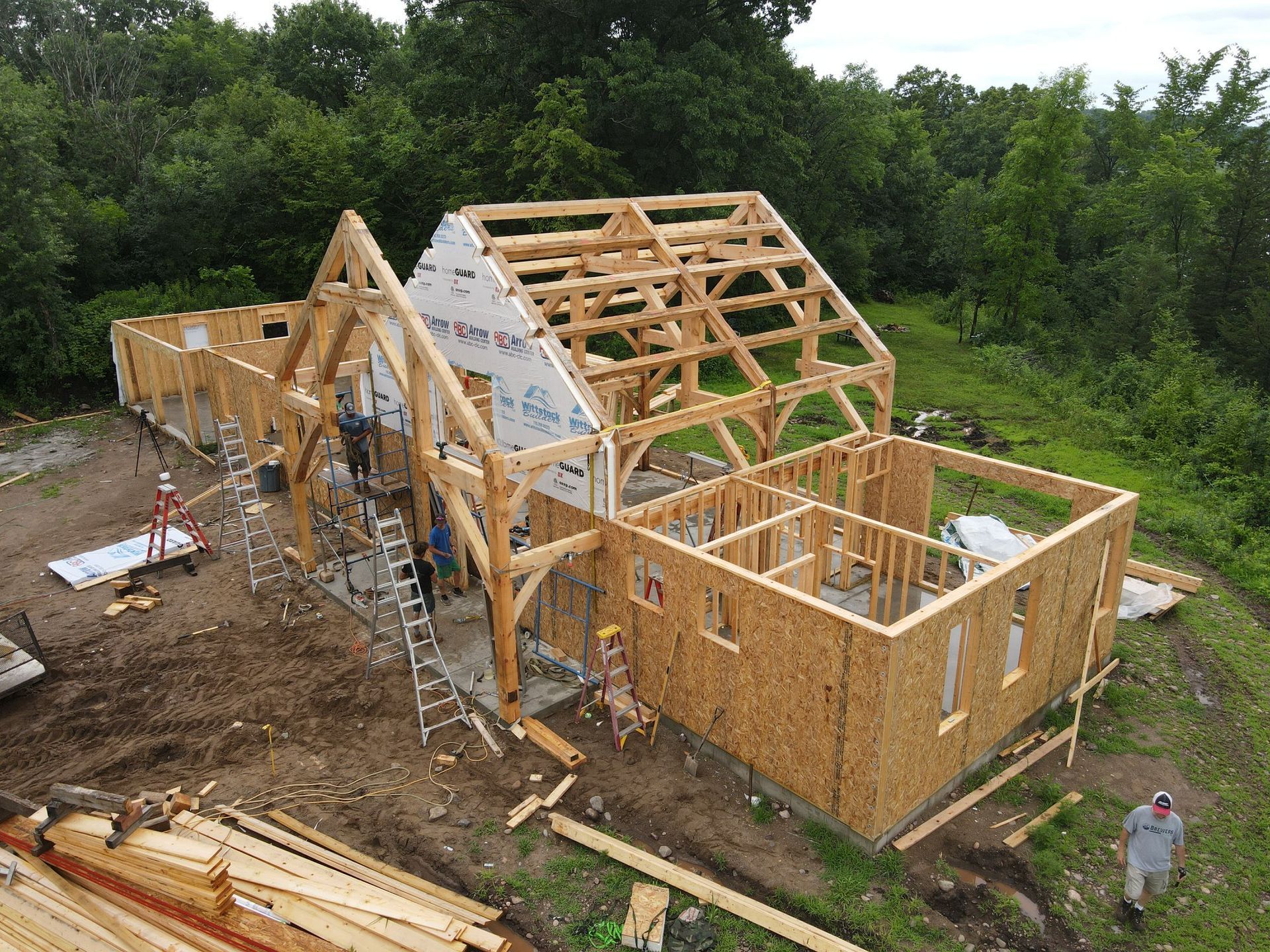 An aerial view of a wooden house being built in a field.