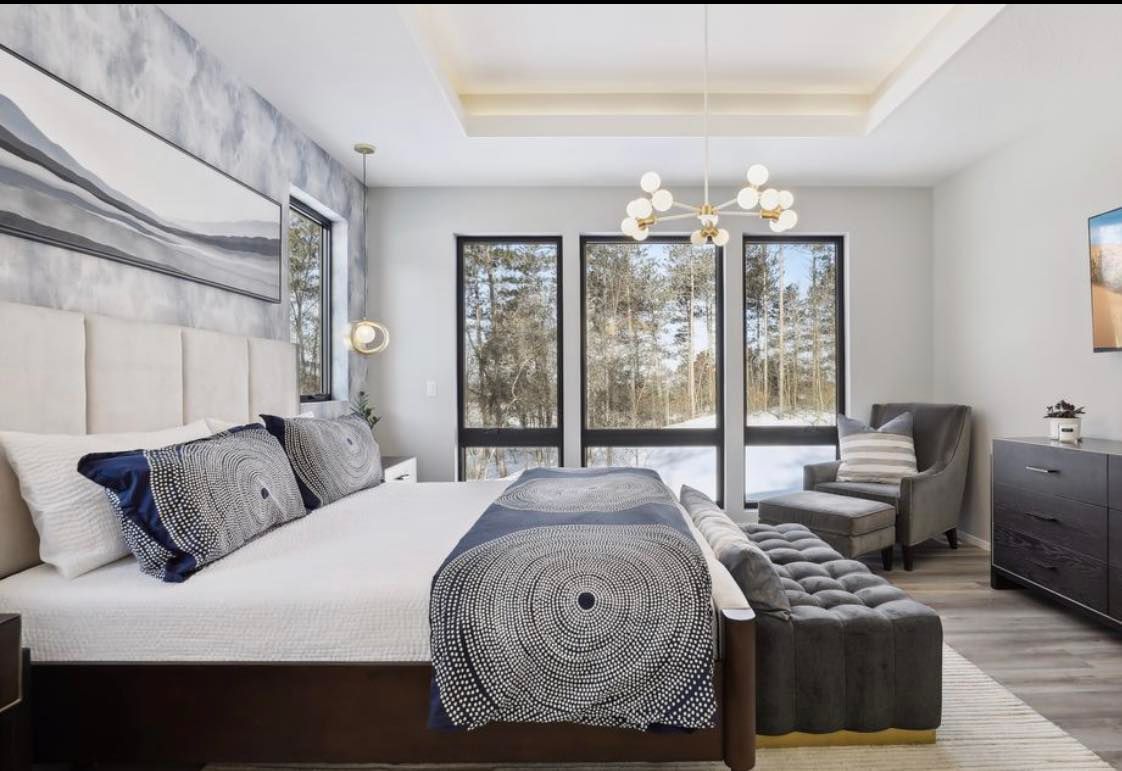 A bedroom with a large bed and lots of windows