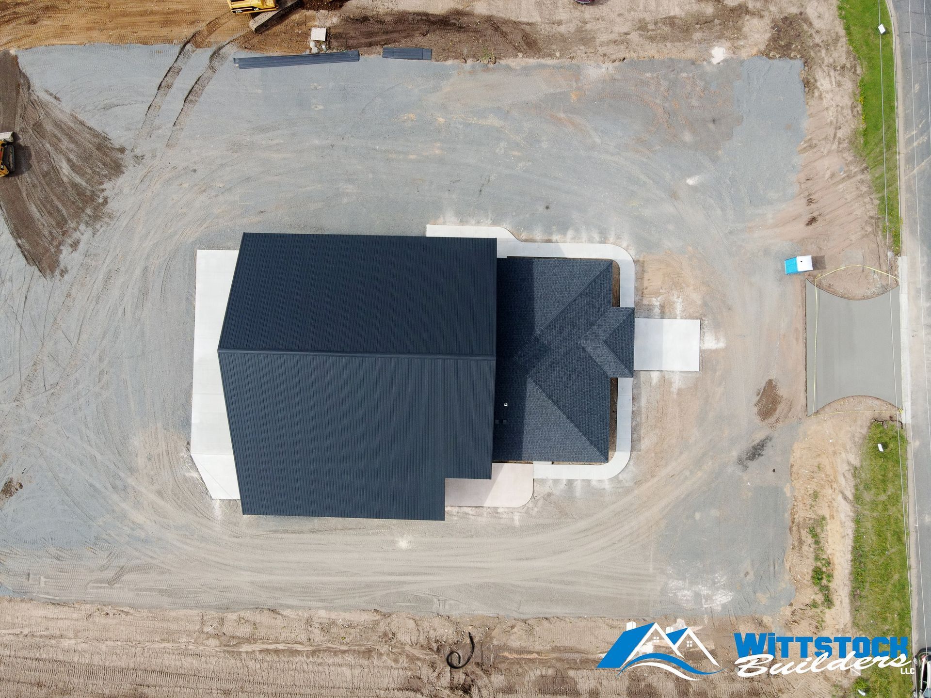 An aerial view of a house under construction in a dirt field.