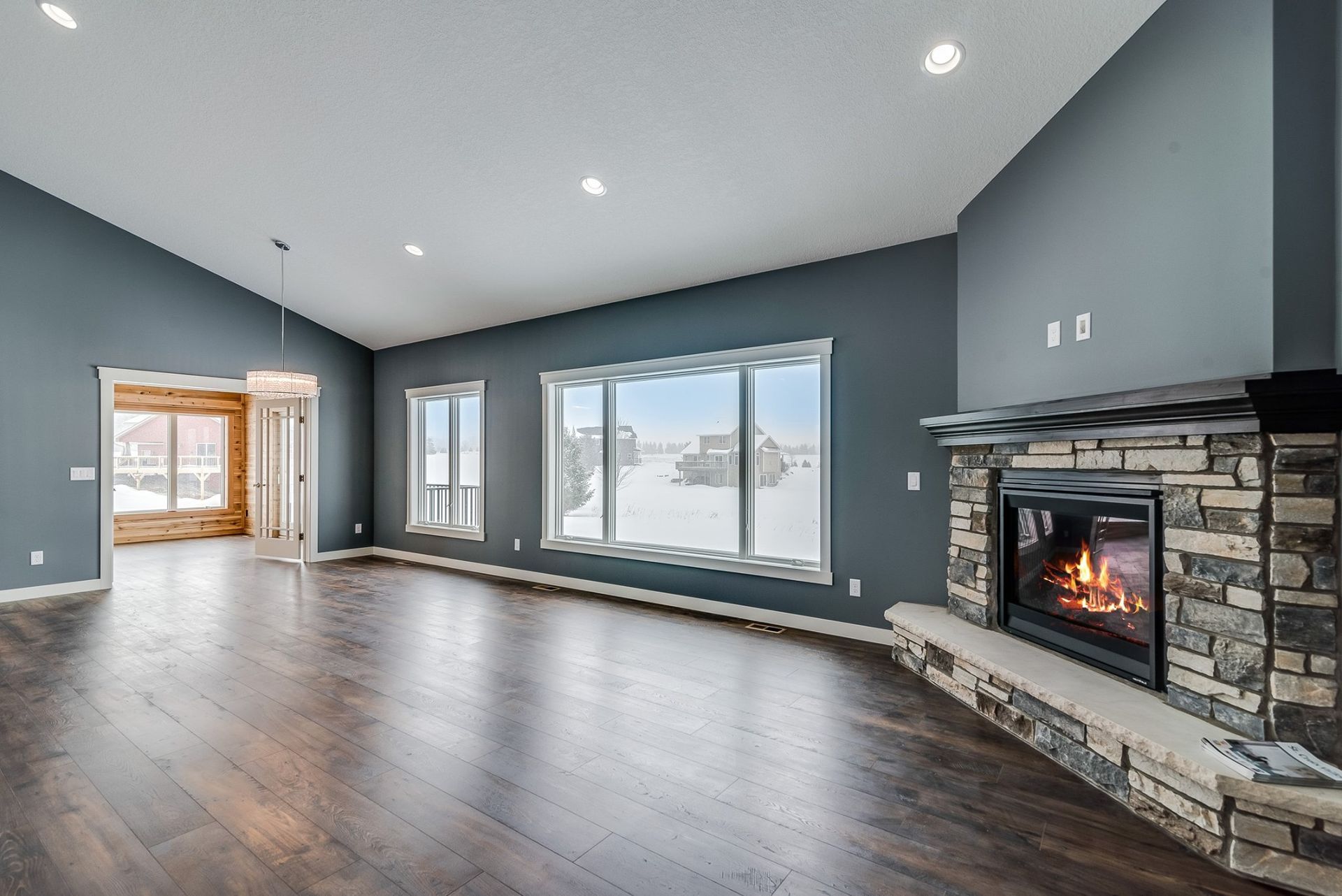 An empty living room with a fireplace and lots of windows.
