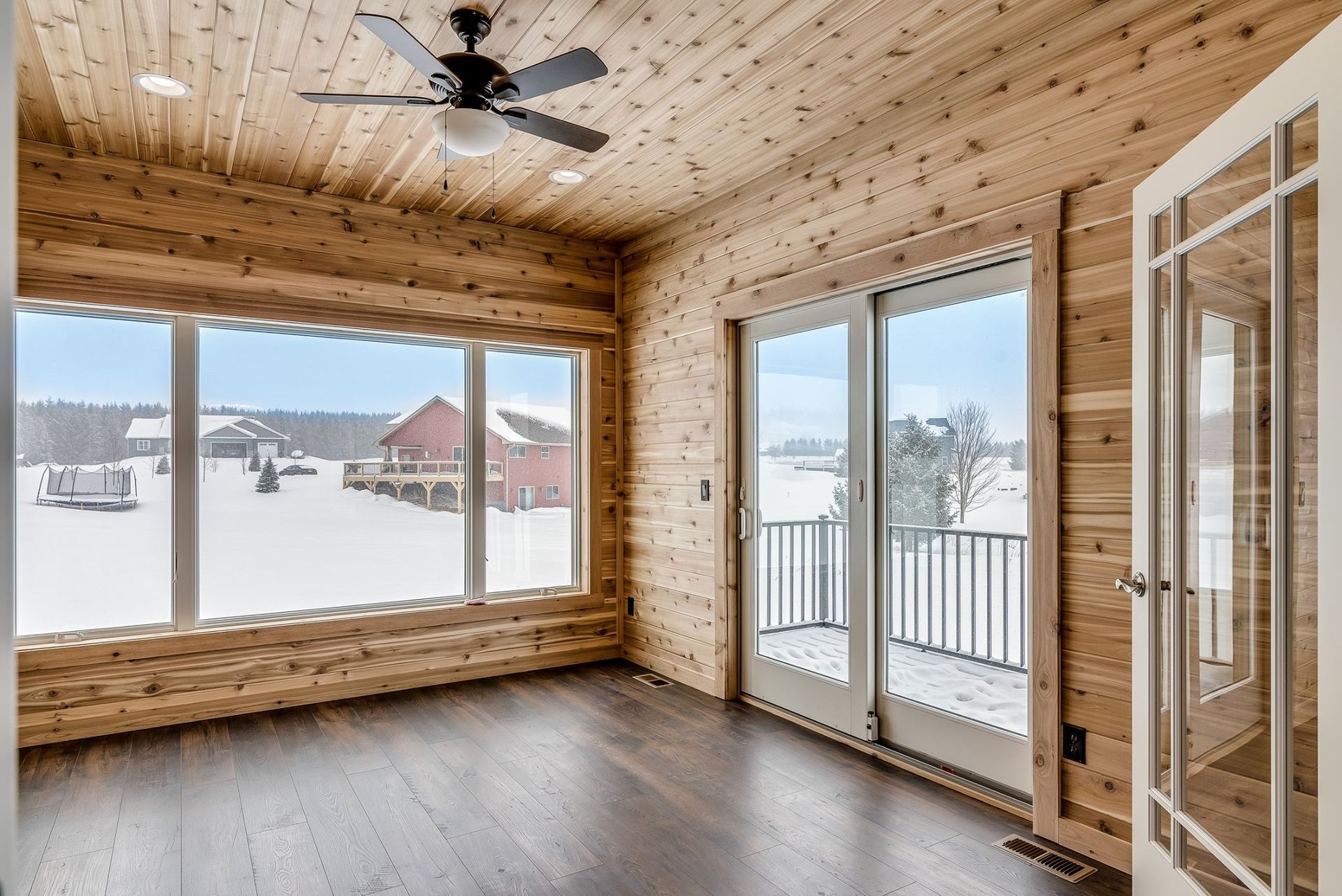 A room with a lot of windows and a ceiling fan.