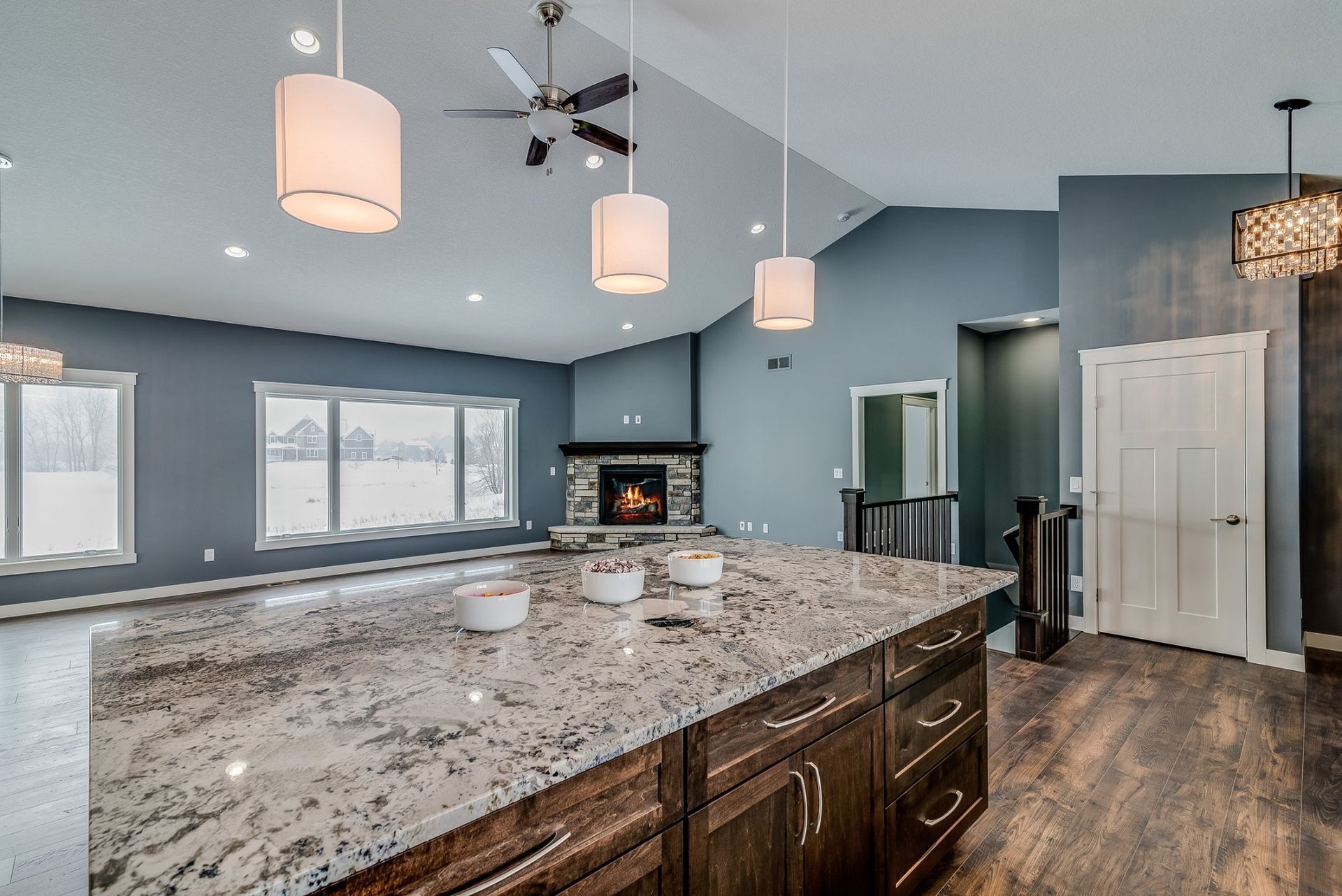 A kitchen with granite counter tops and a ceiling fan.