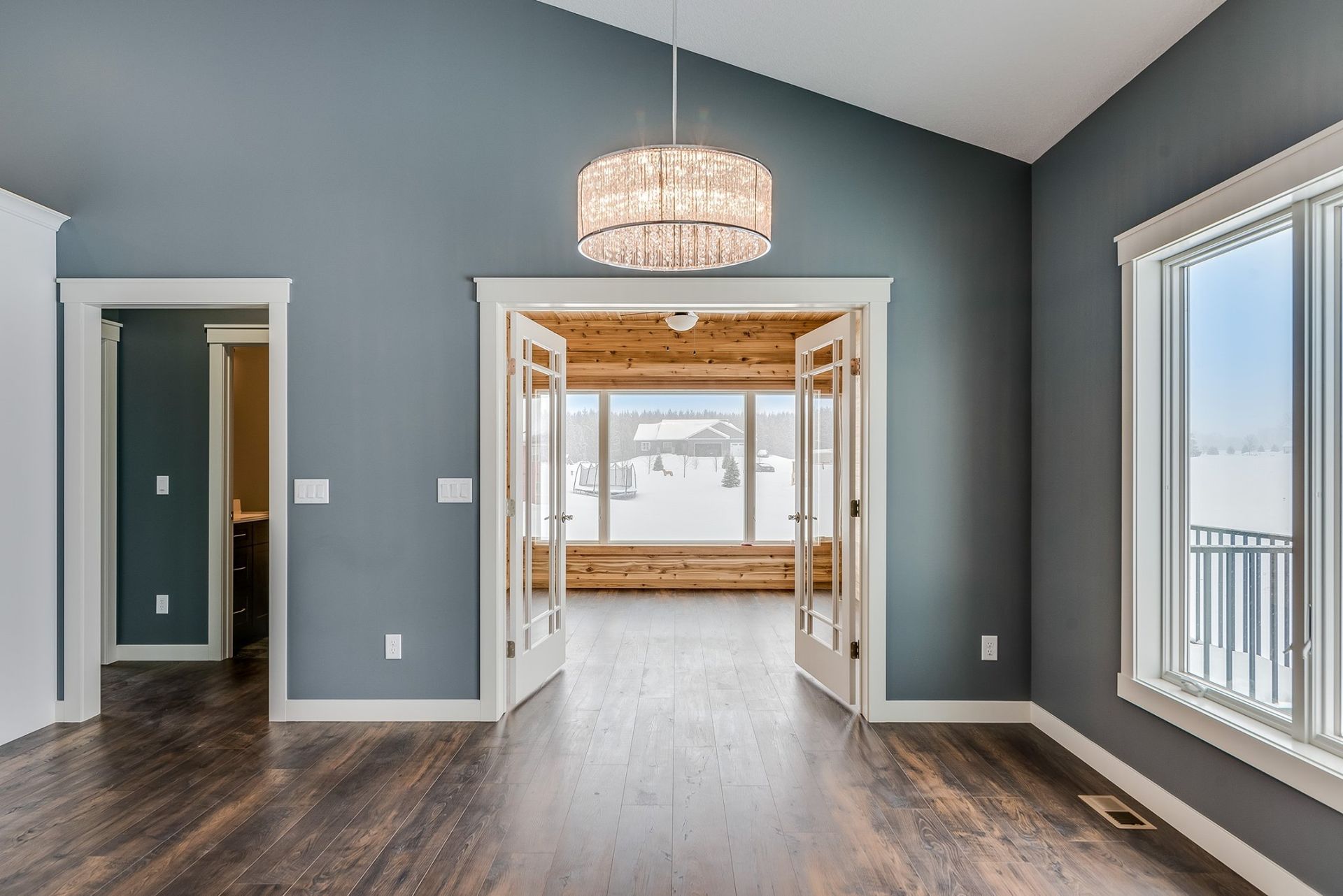 An empty room with a vaulted ceiling and lots of windows
