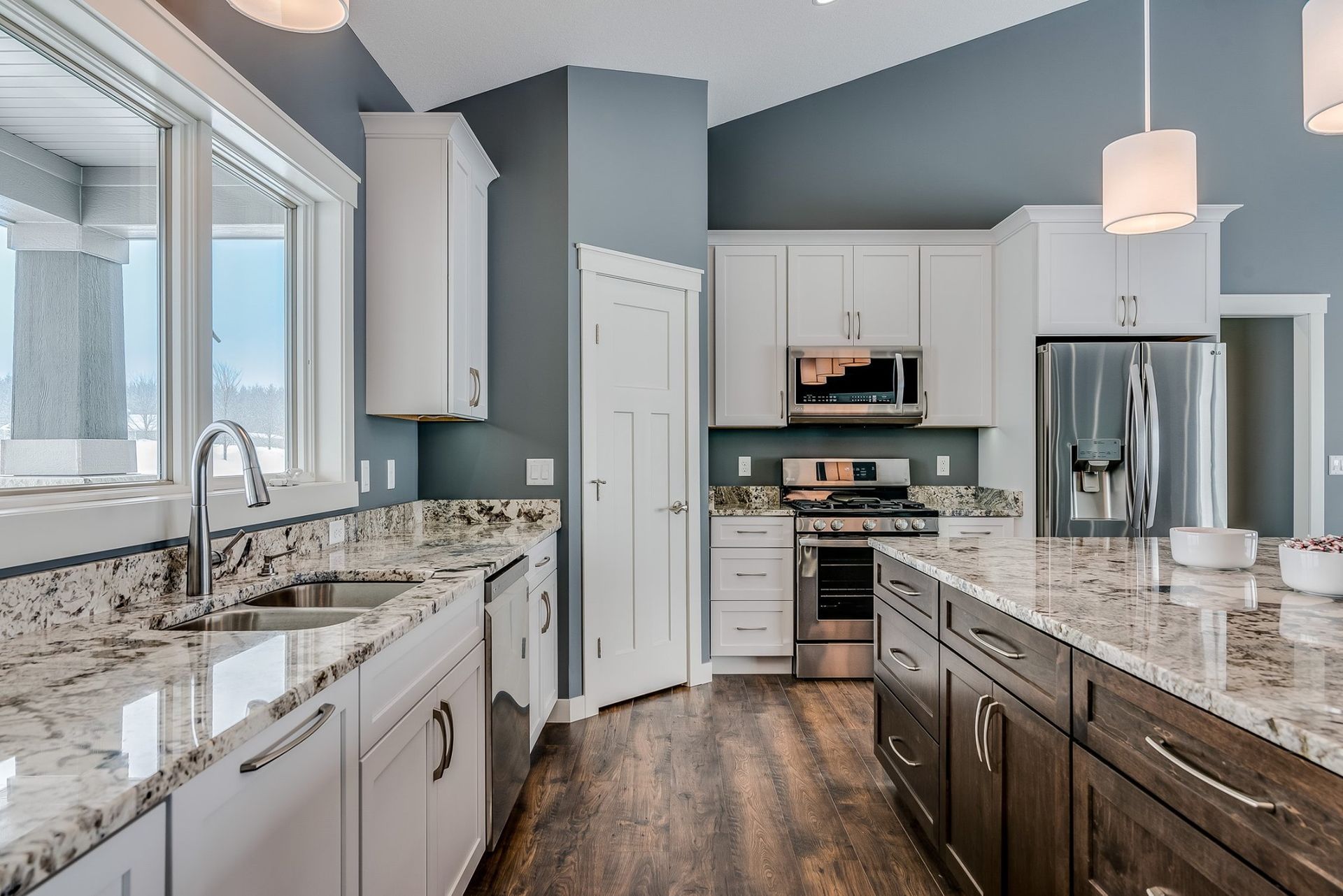 A kitchen with granite counter tops and white cabinets
