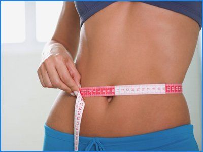 Woman checking the waste size with a measure tape
