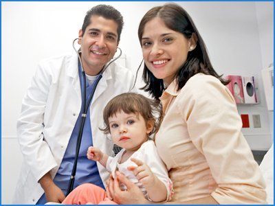 Smiling doctor with baby & his mother