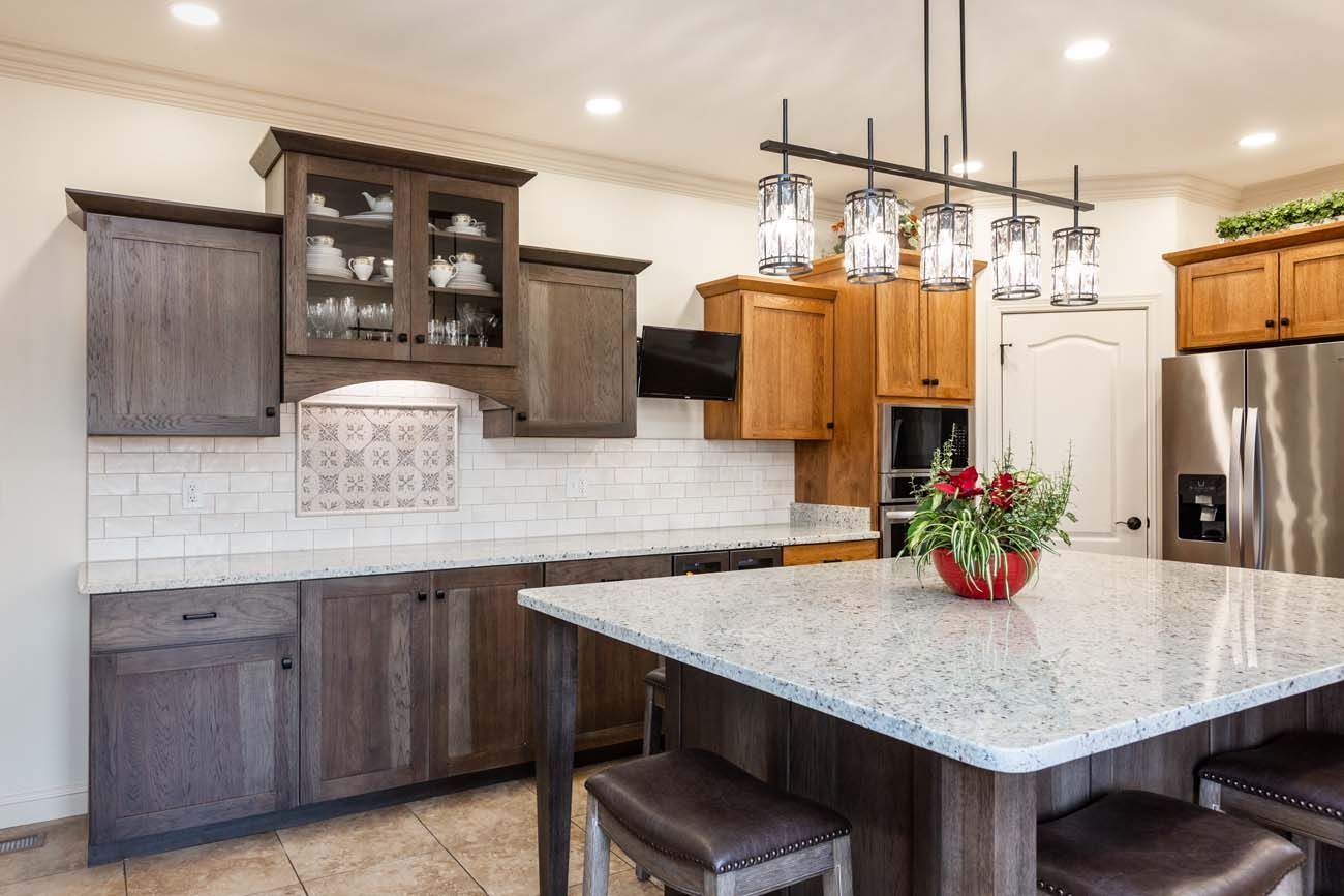 Kitchen with dark and light wood cabinets, granite island, and stainless steel appliances.