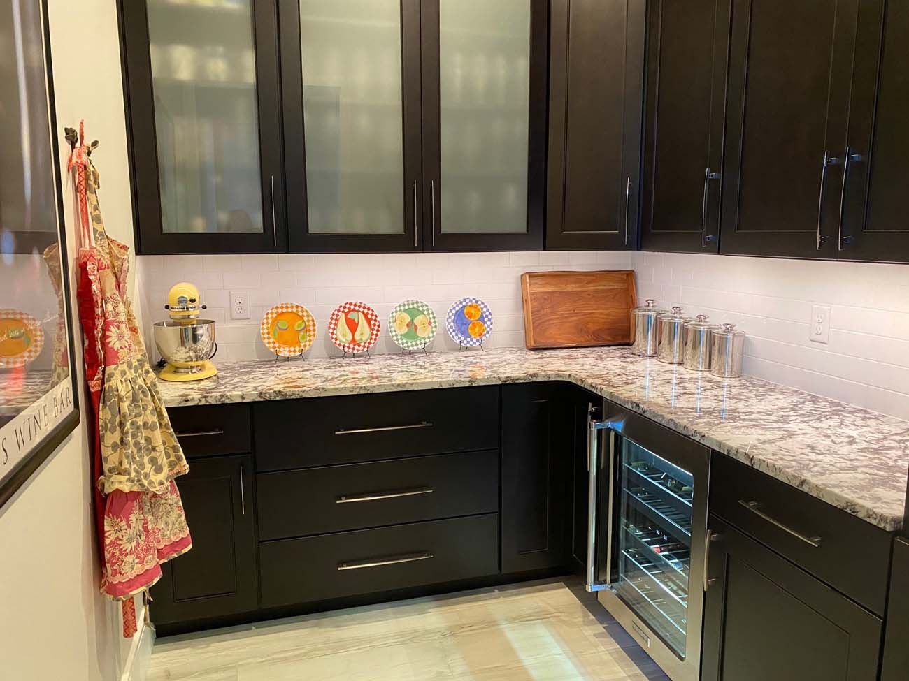 Black pantry with a granite countertop and a wine fridge.