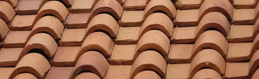 Close-up of a tiled roof with rows of overlapping, semi-circular terracotta tiles.