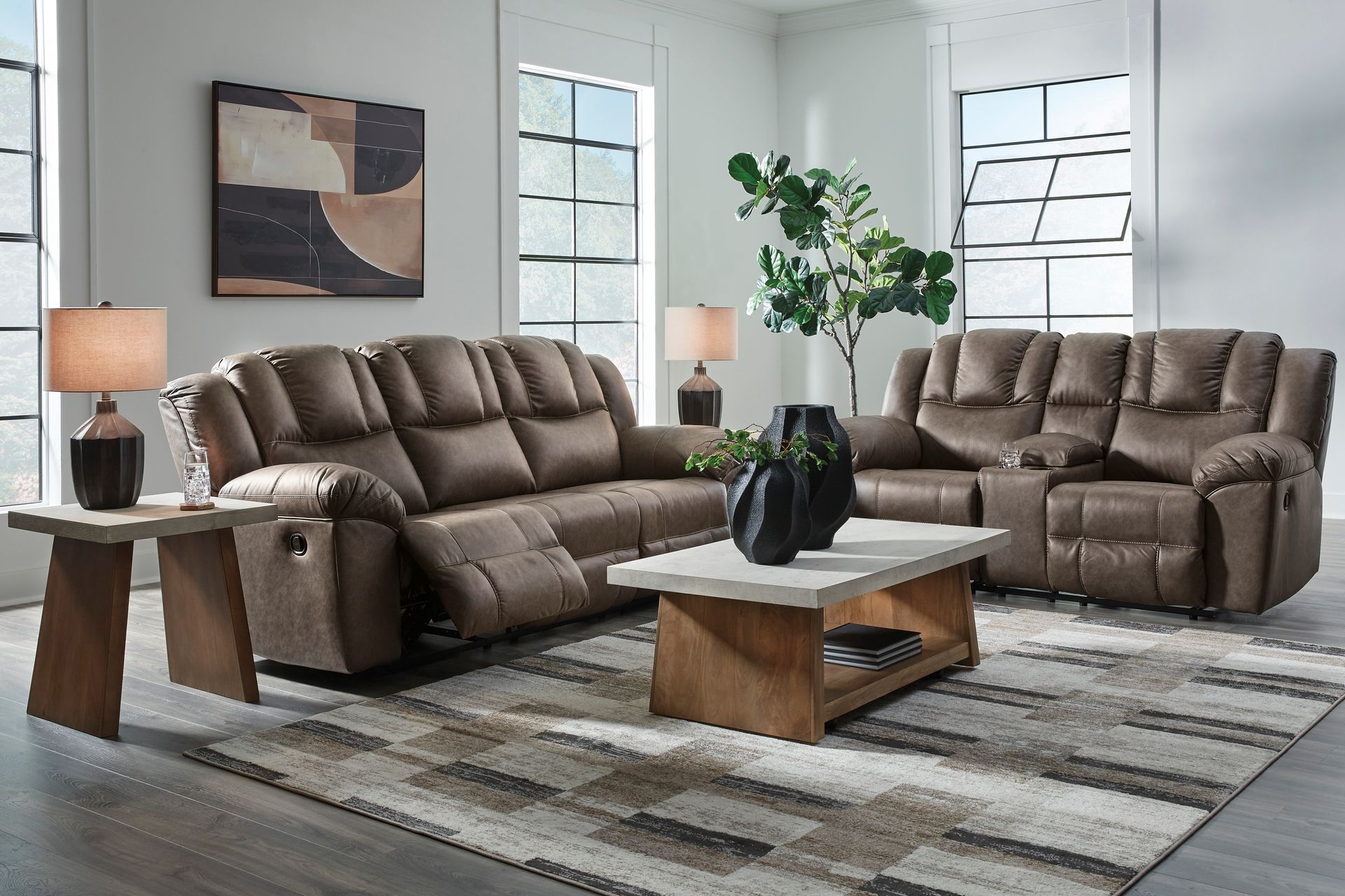 Living room furniture set with brown reclining sofa, loveseat, coffee table, and area rug.