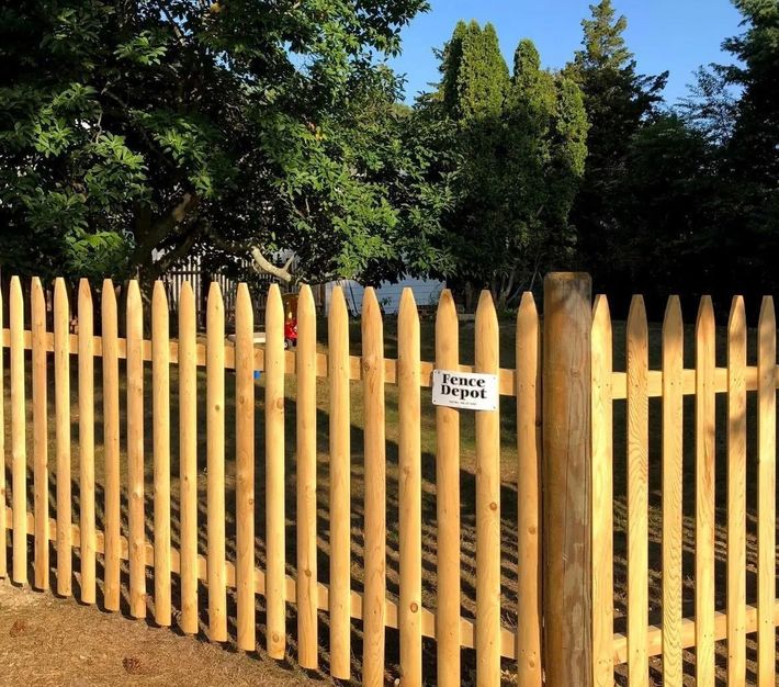 A wooden picket fence with a sign