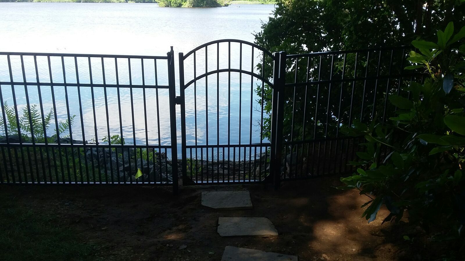 A wrought iron gate leading to a body of water