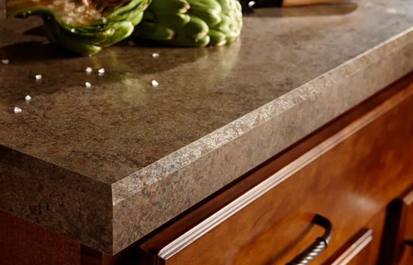 A kitchen counter with a cutting board and vegetables on it.