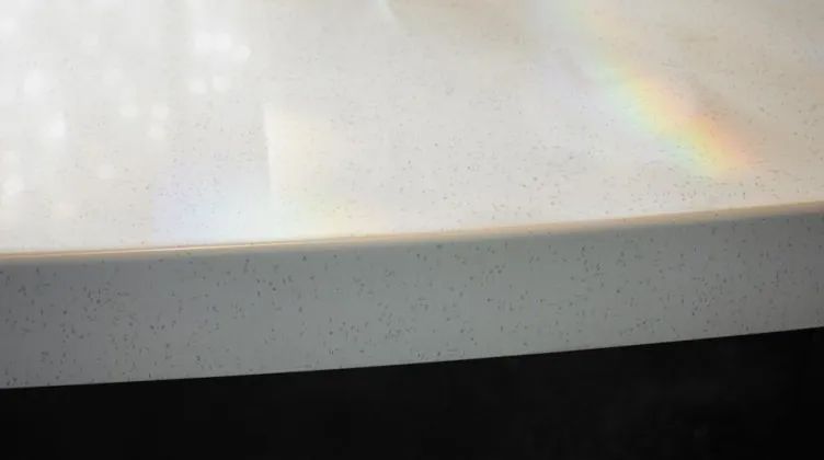 A rainbow is visible on a white countertop surface.