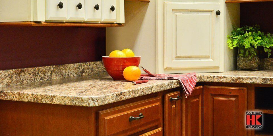 A kitchen counter with a bowl of lemons and oranges on it