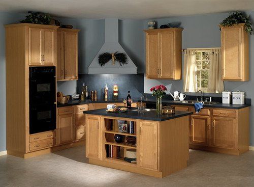 A kitchen with wooden cabinets and black counter tops