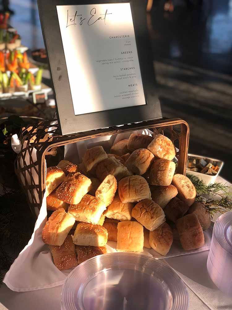 a basket of rolls is sitting on a table next to a menu