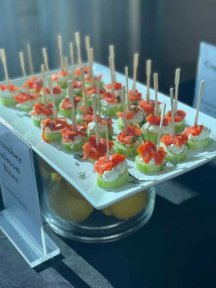 a white plate topped with cucumber appetizers on toothpicks