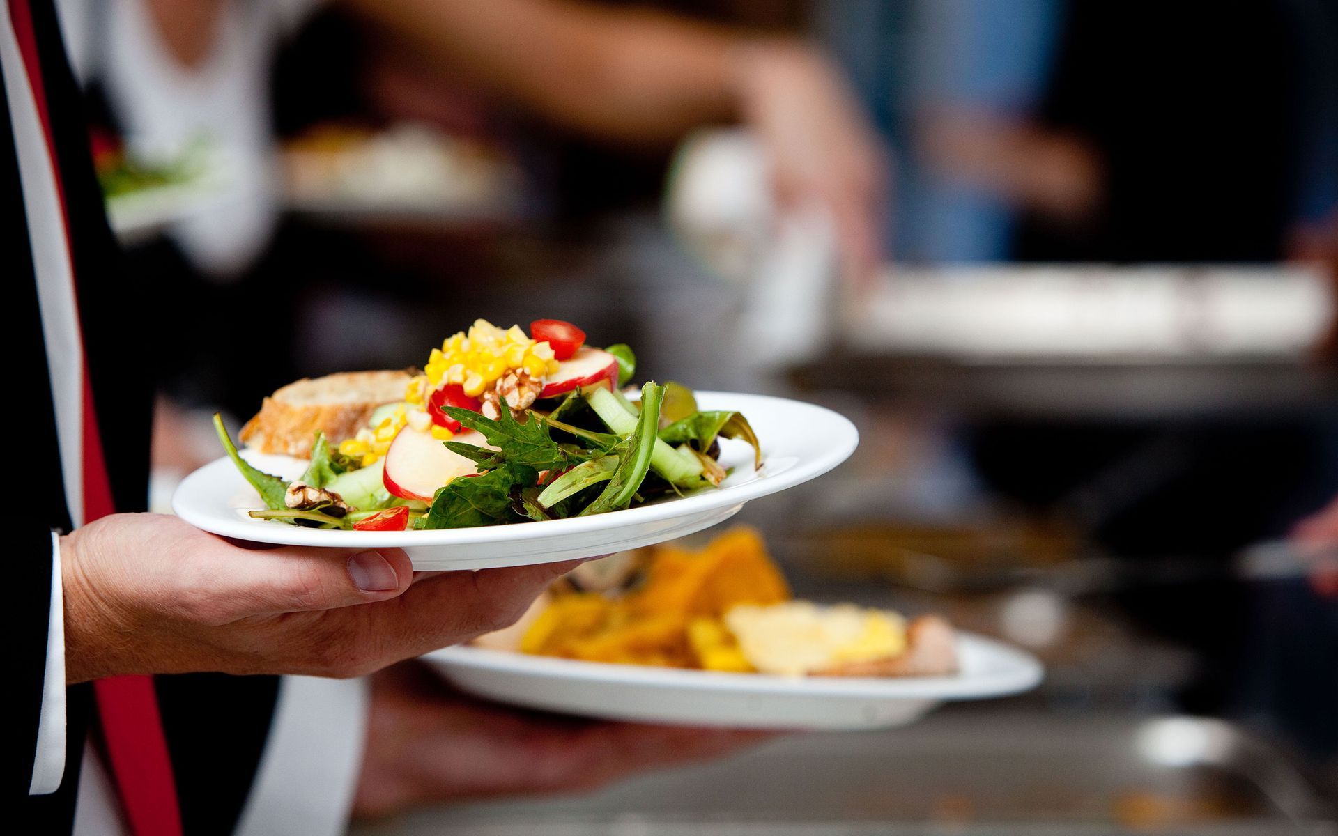 a person is holding a plate of food in their hand
