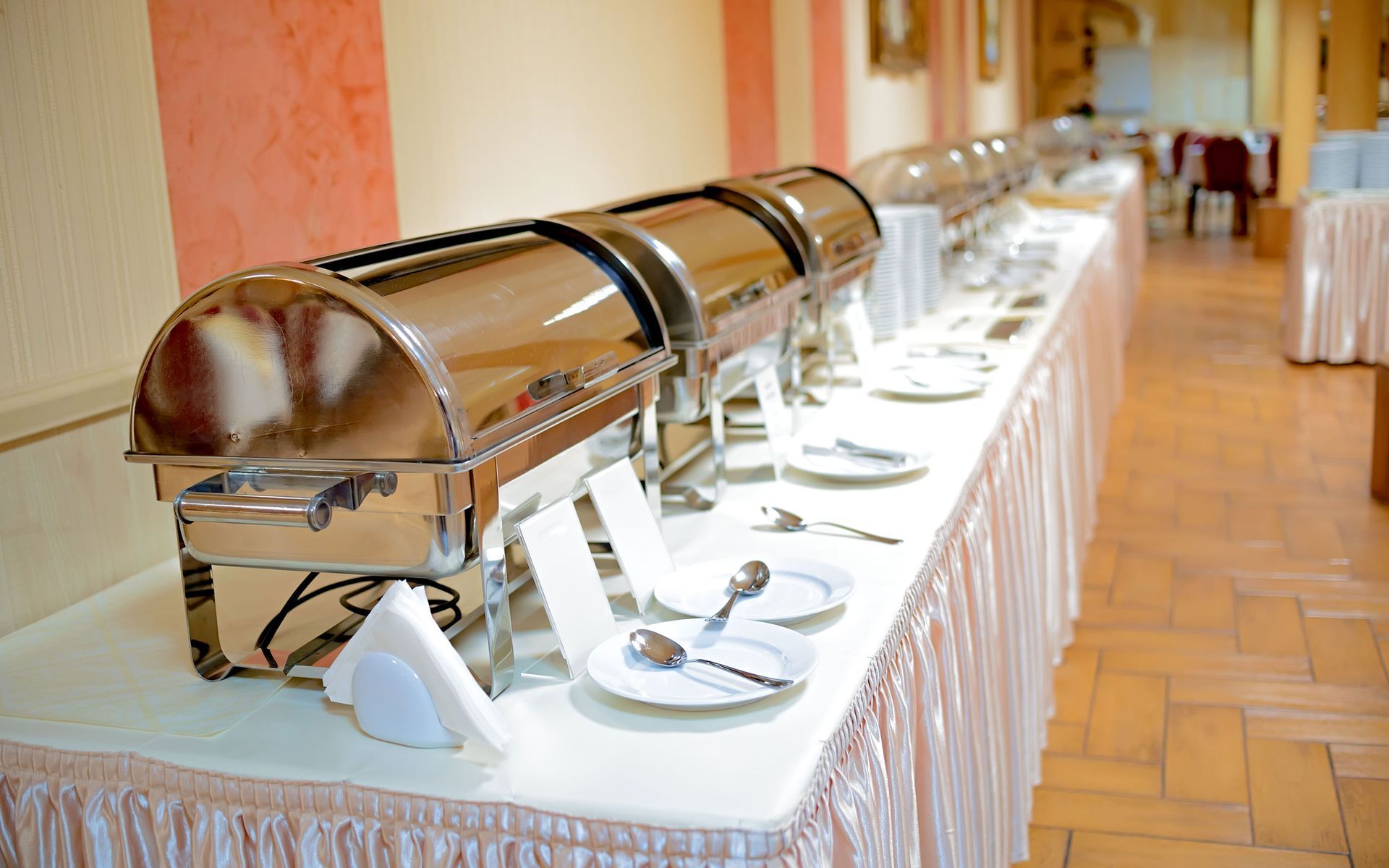 a long table with plates , utensils , and a buffet .