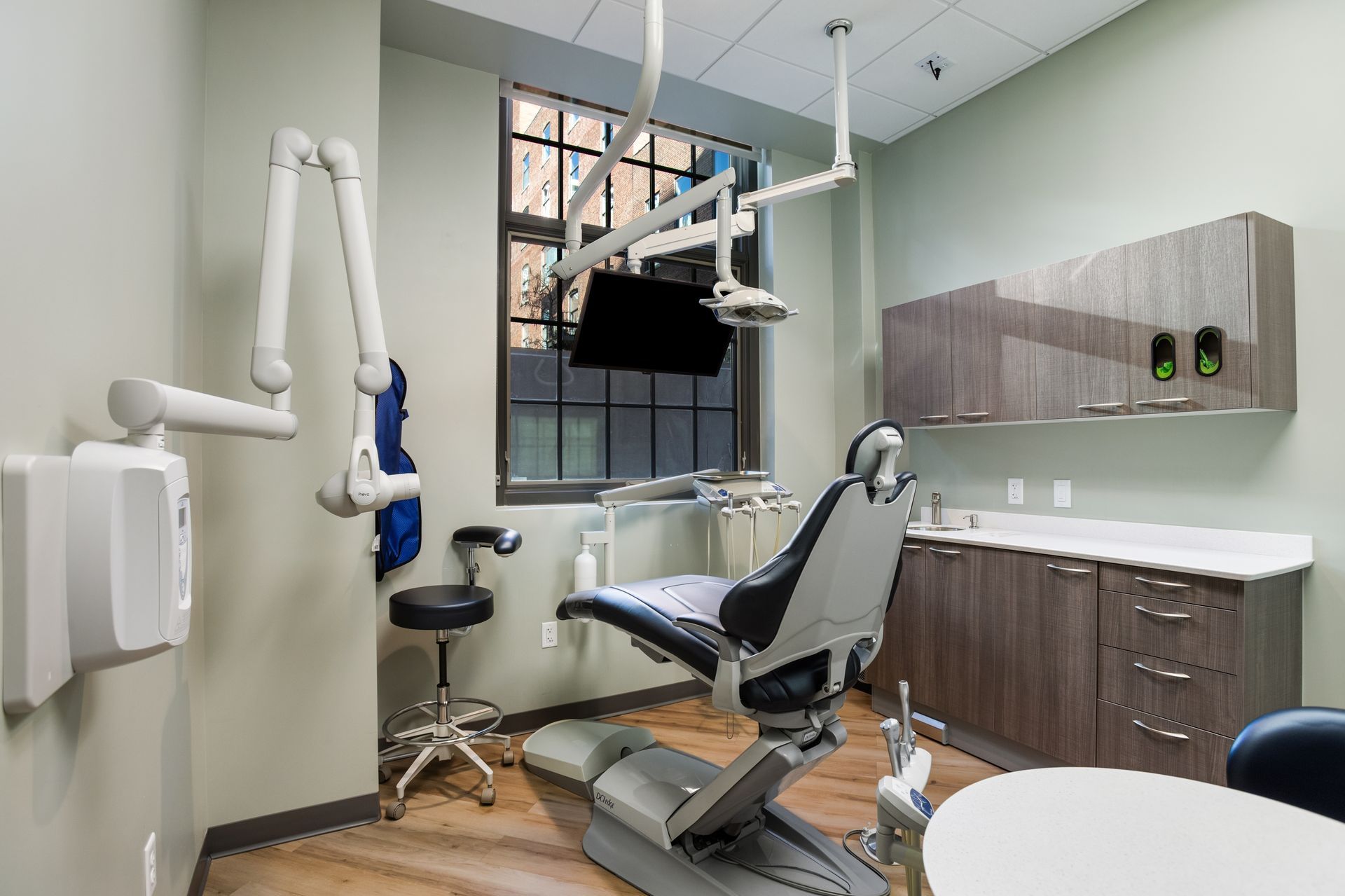 Dental office with a dental chair, cabinets, and an x-ray machine.