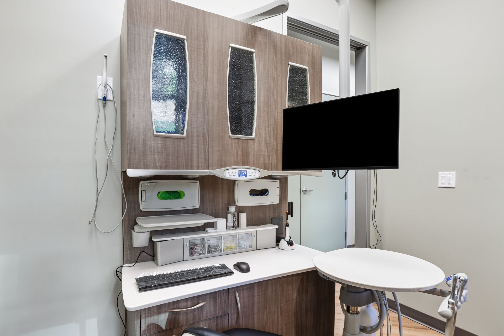 Examination room station with a desk, monitor, and medical equipment.