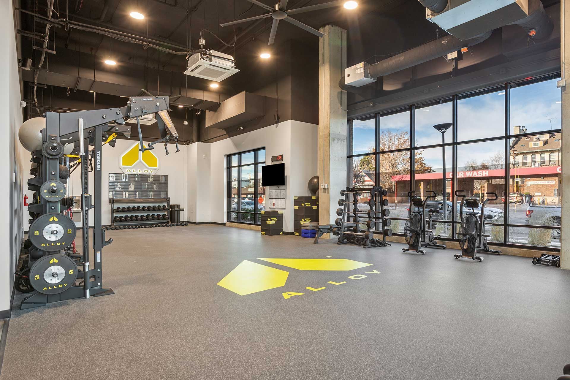 gym interior with weights, machines, and large windows